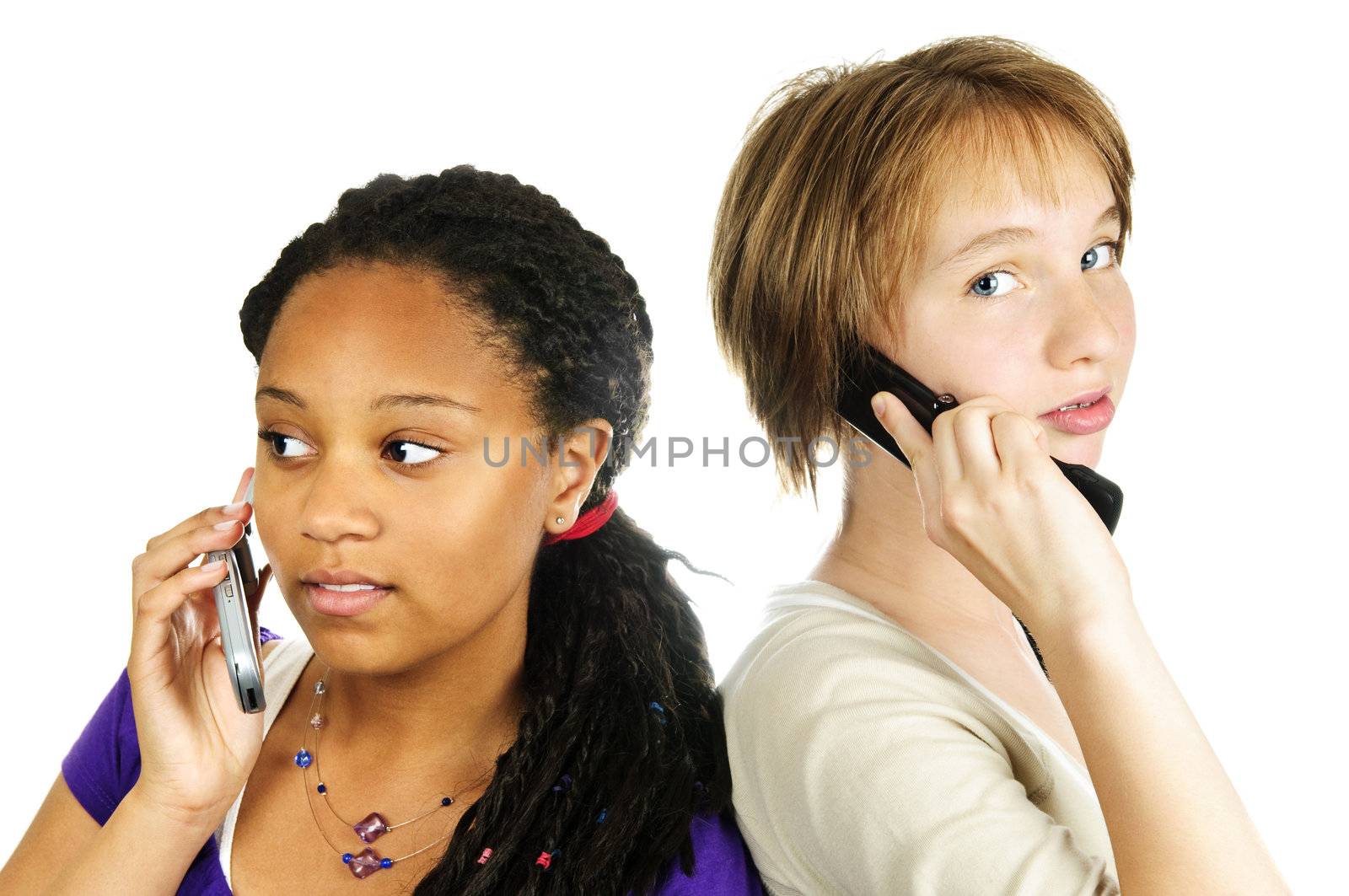 Isolated portrait of two teenage girls with cell phones