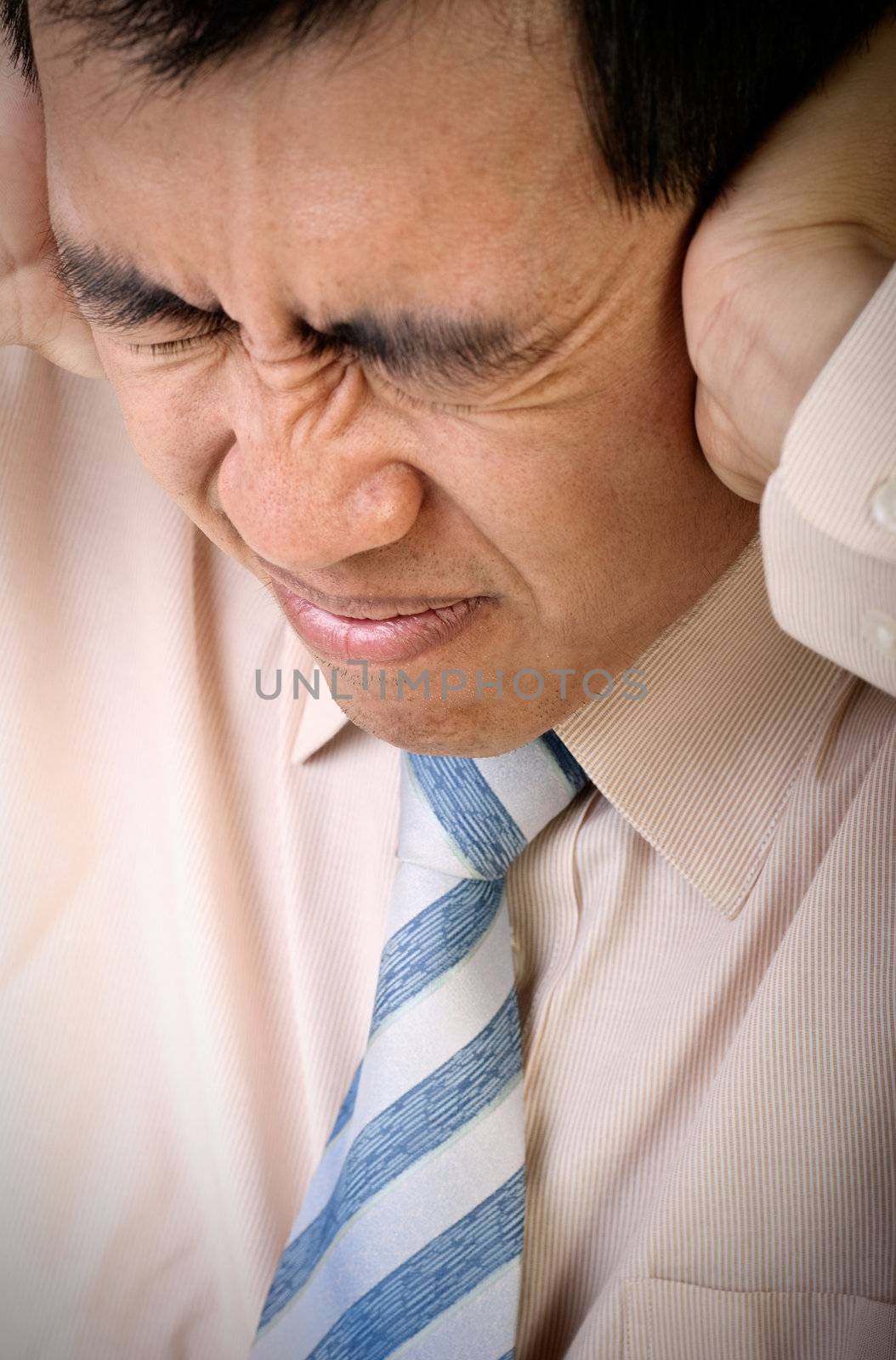 Stress of businessman with pain expression holding head by hands.