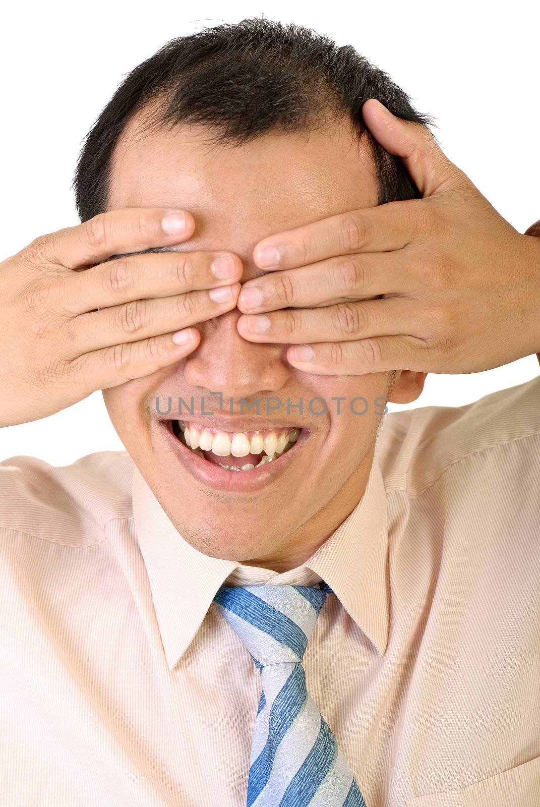 Blind happy smiling businessman of Asian cover eyes by hands on white background.