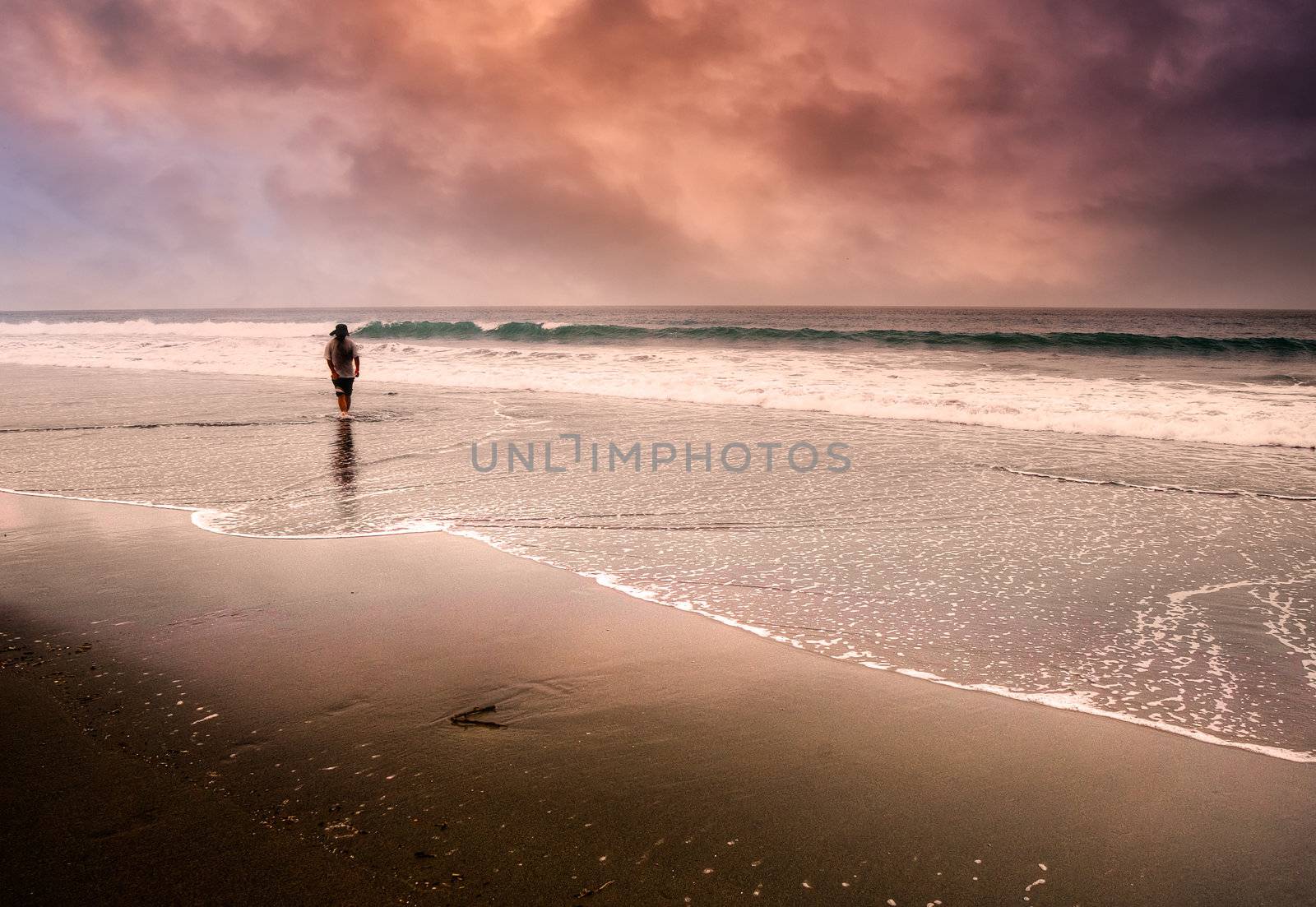 One man walking lonely at the dramatic and beautiful beach.