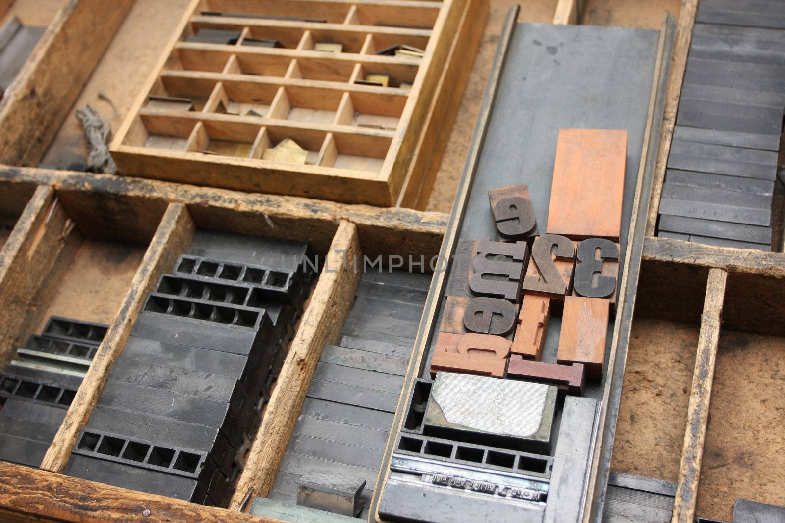 An old fashioned type setters workshop, the tools and typescripts lying in a worktop