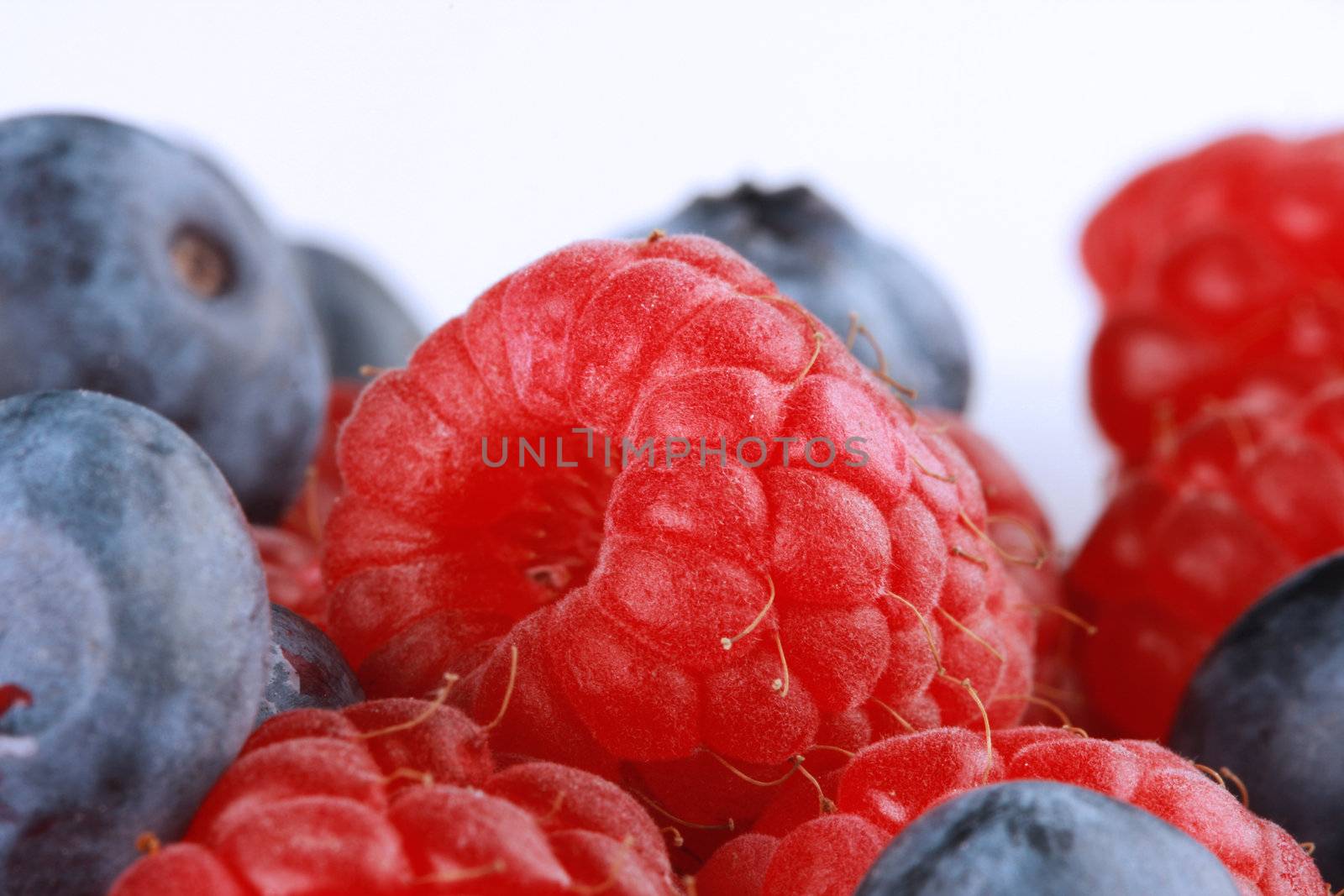 Juicy berries isolated on white, shot with blue filtered light