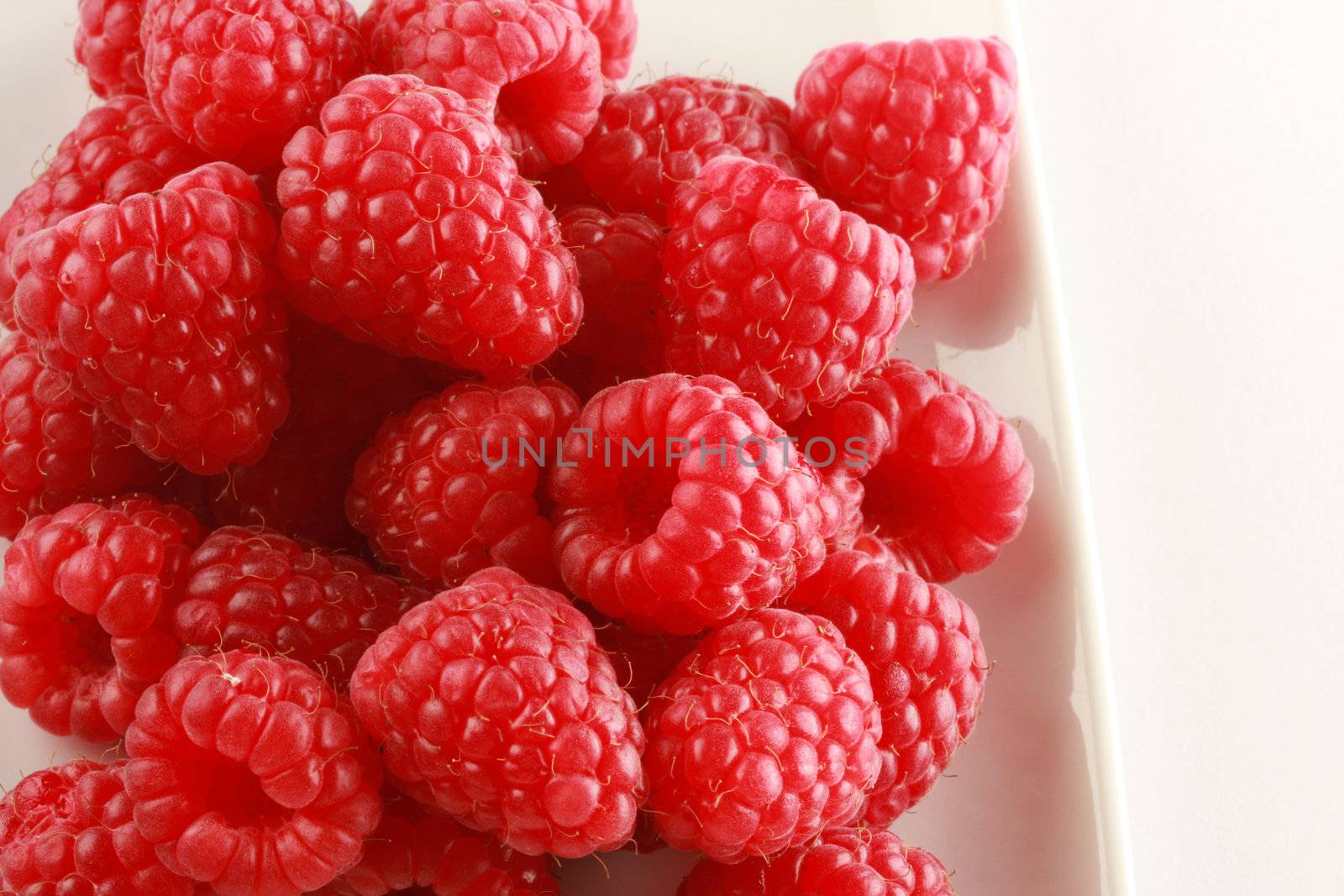 bowl of raspberries by sumos