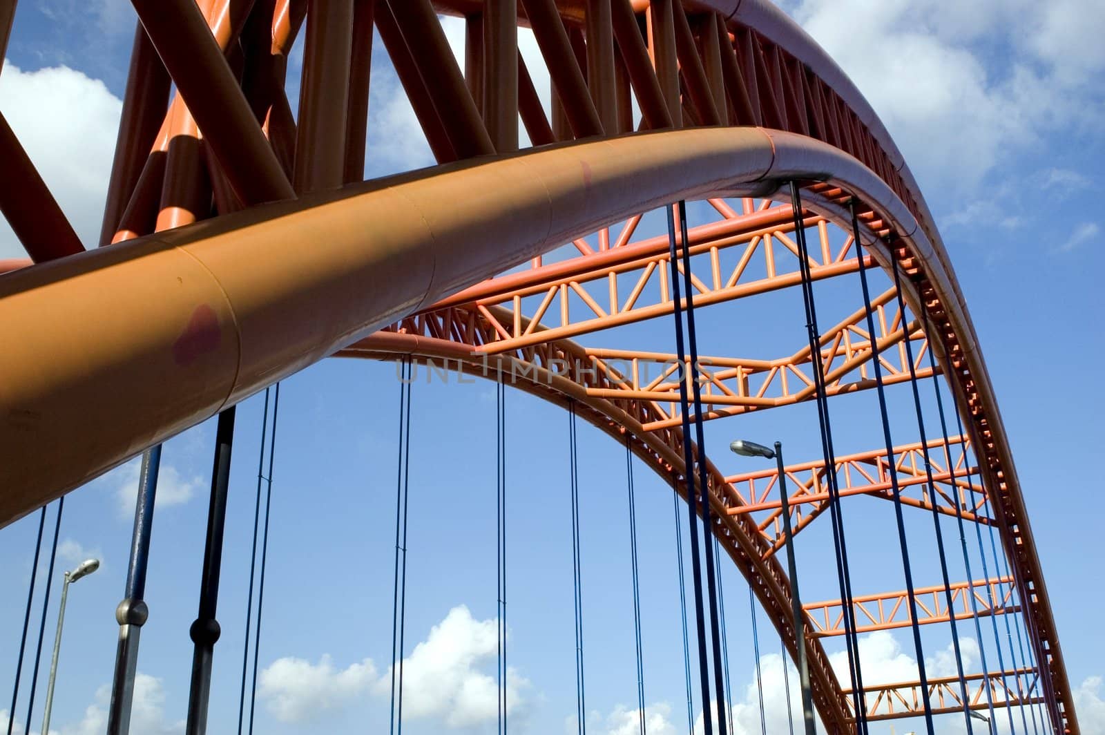 Original orange bridge structure with blue sky and clouds as bacground.