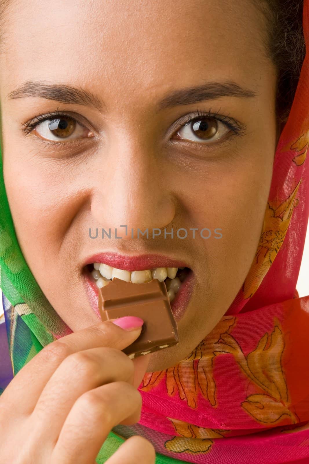 The beautiful woman eats chocolate close up