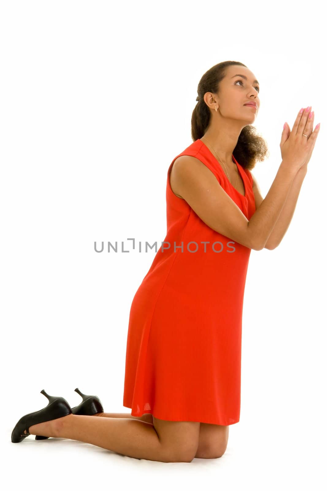 Pray. The beautiful woman prays, kneeling on a white background