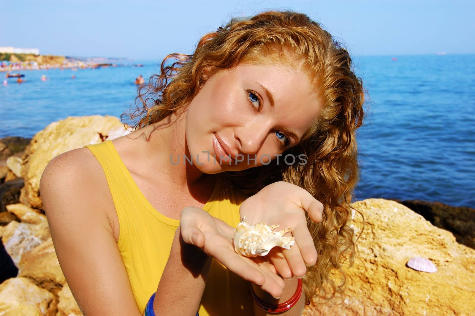 beautiful girl holds a seashell in hands