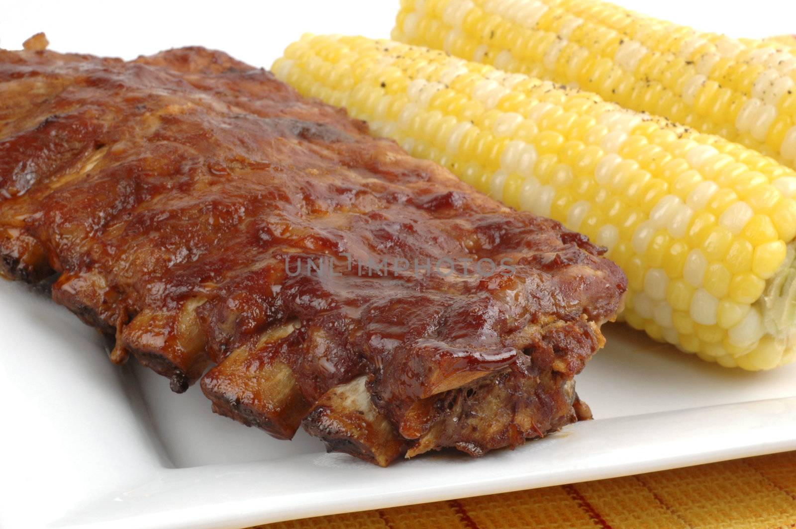 Rack of delicious ribs with corn on the cob.