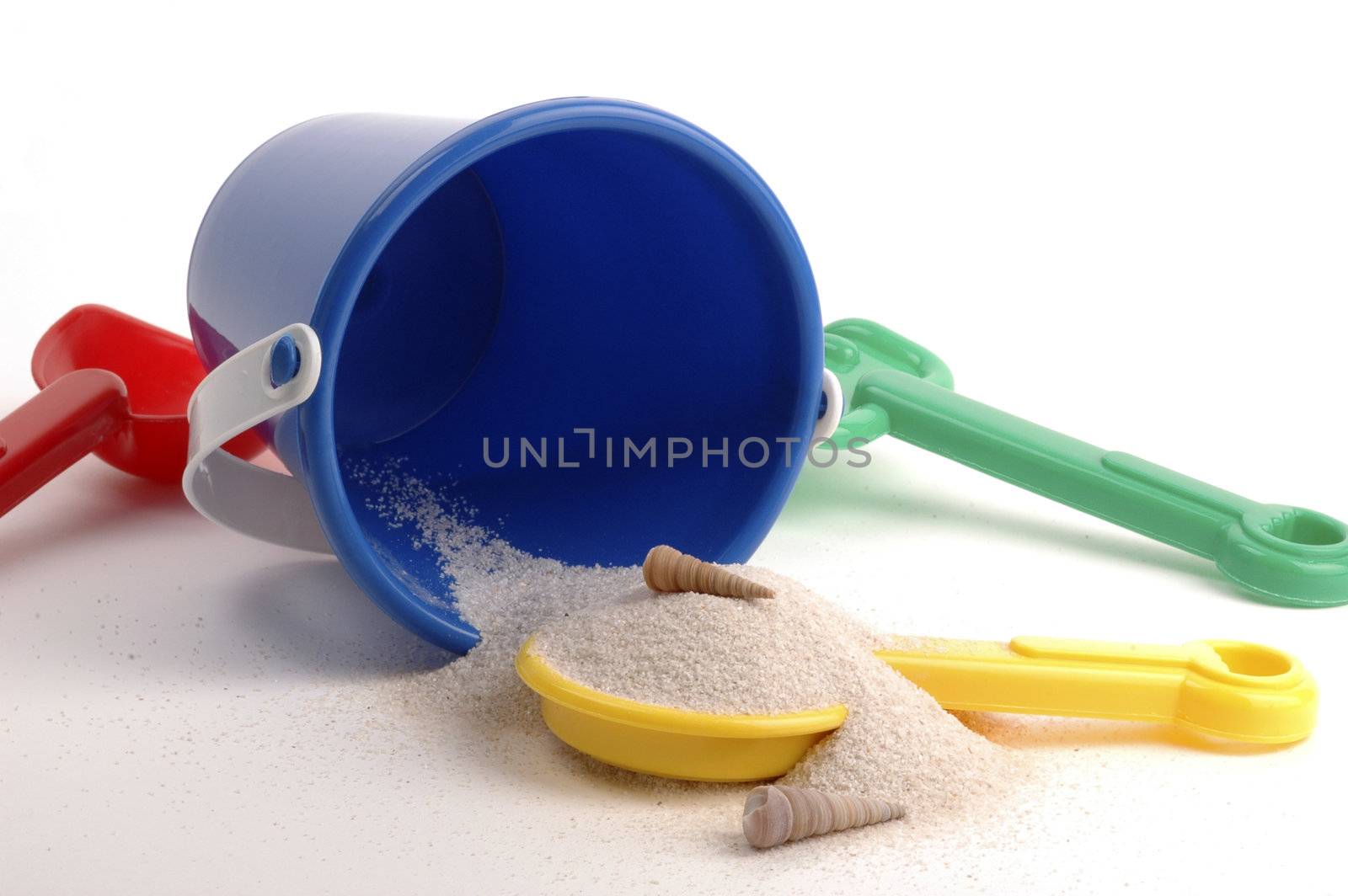 Colorful child's beach toys on a white background.