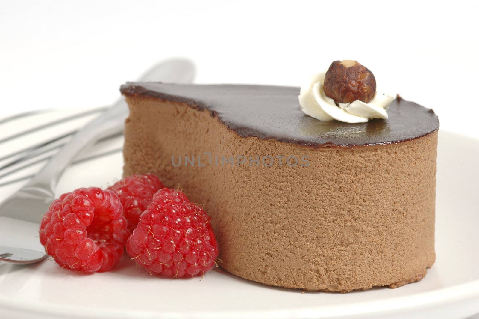 Chocolate mousse dessert served with raspberries.