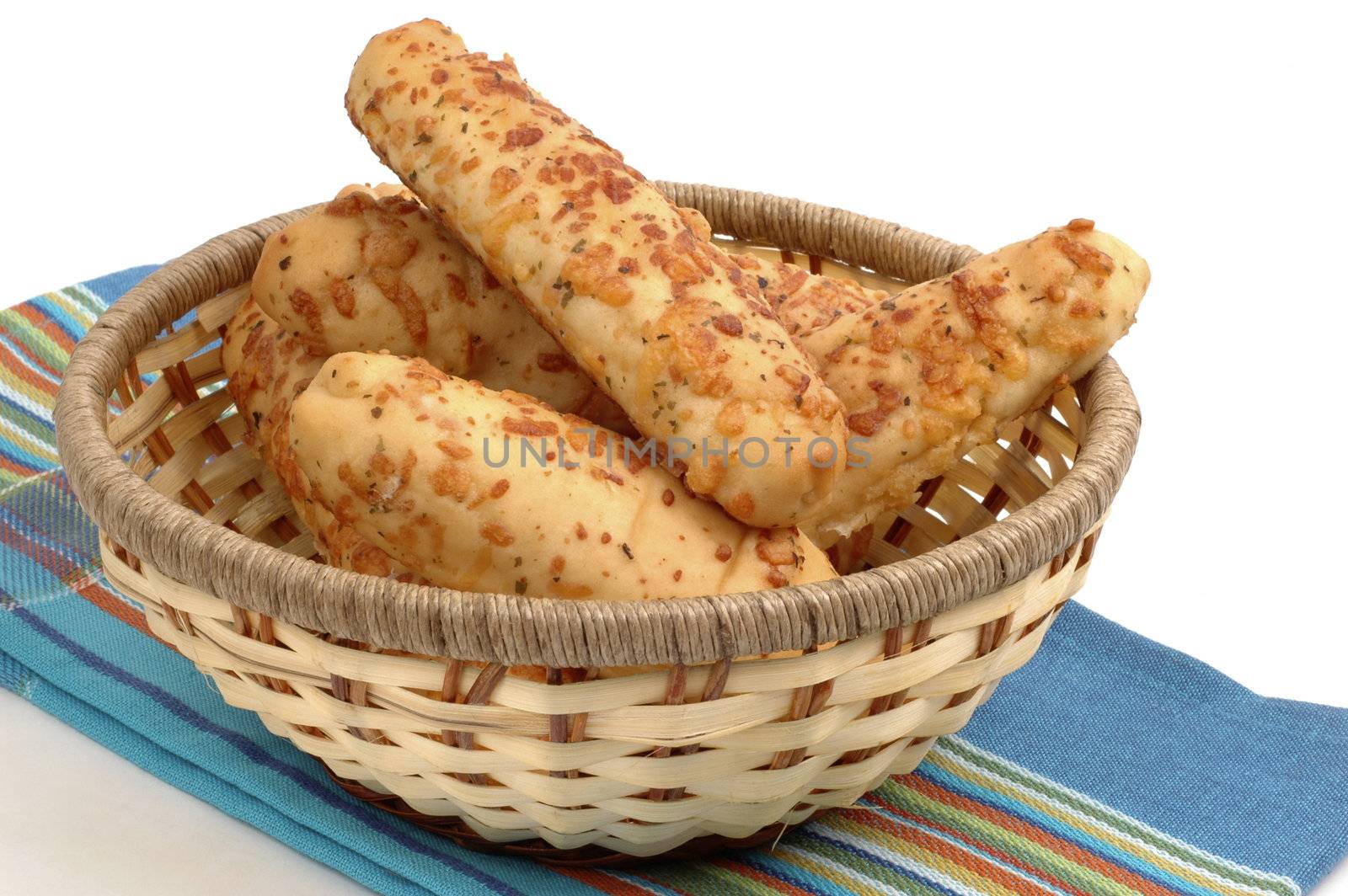 Fresh baked garlic and cheese breadsticks in a basket.