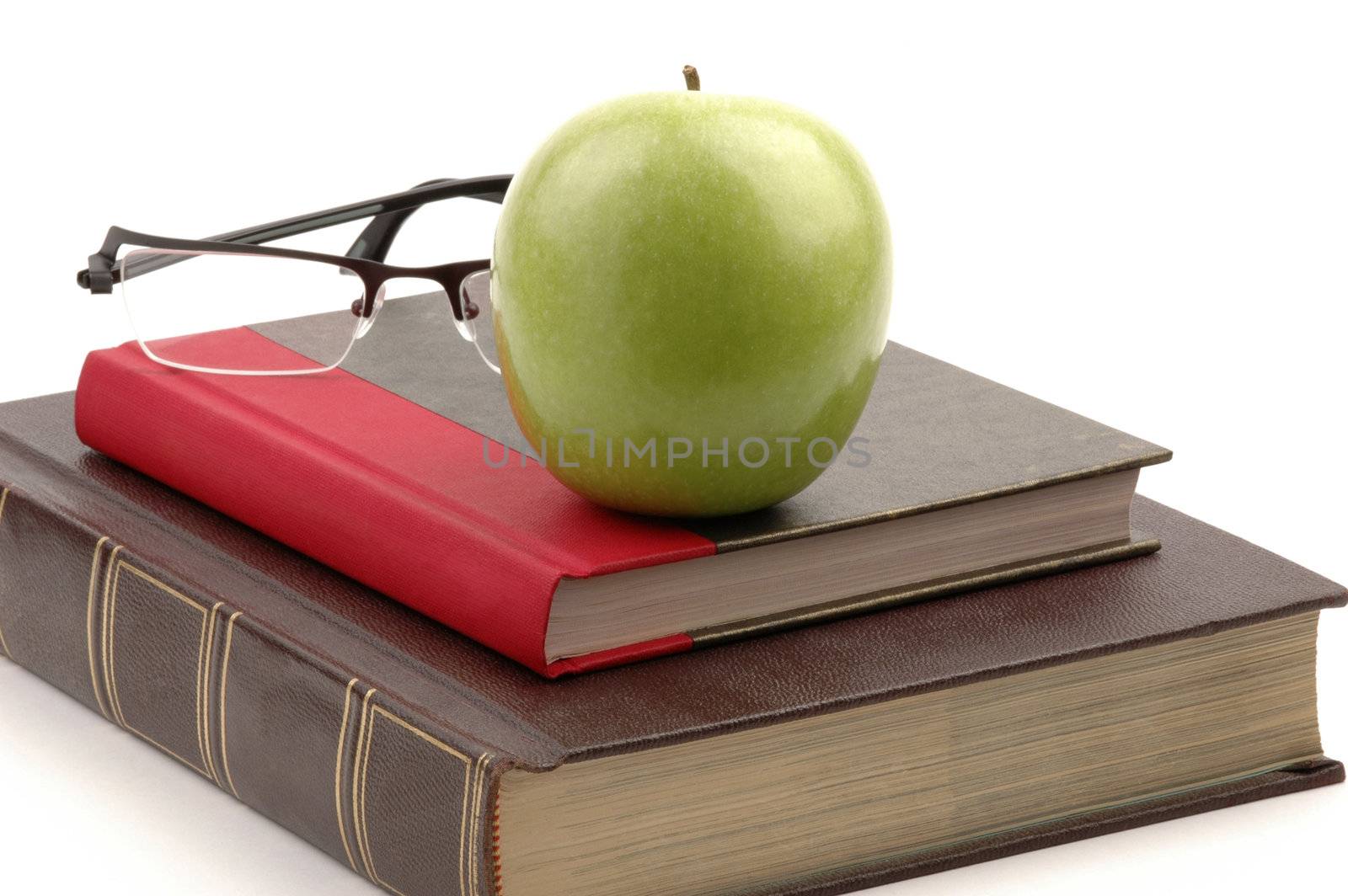 Hardcover school books and apple still life.