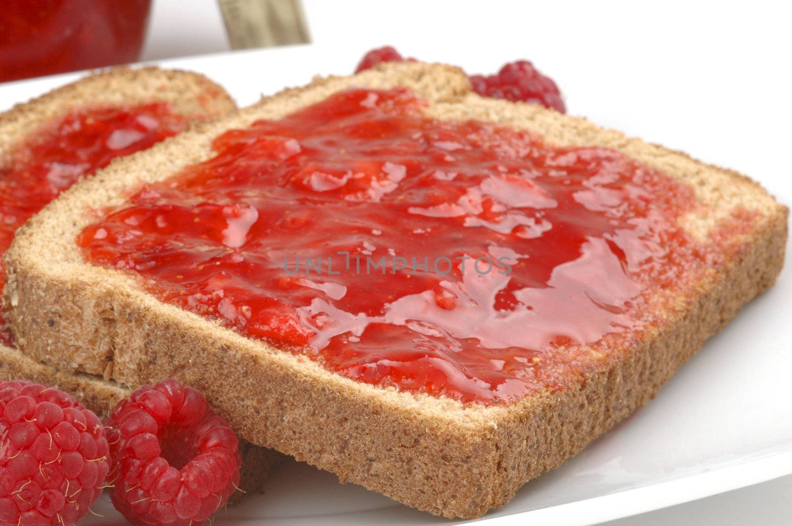 Toast with home made raspberry jam and raspberries.