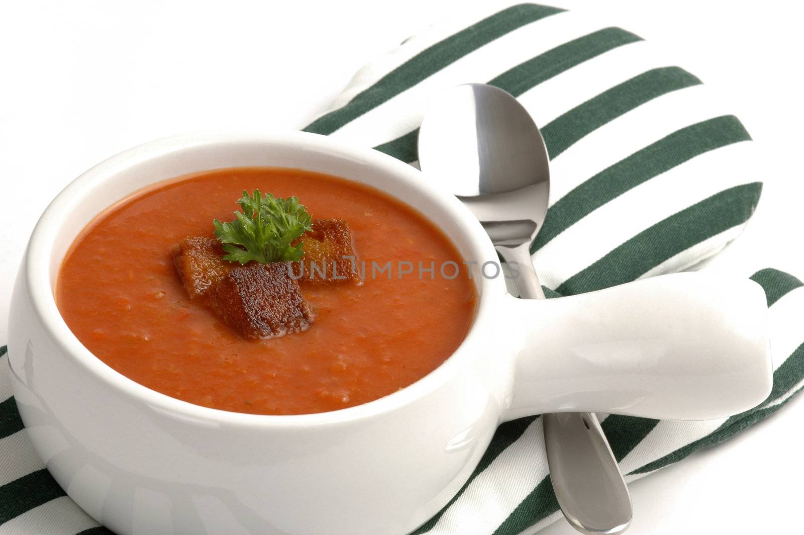 Bowl of garden tomato soup with croutons and parsley.