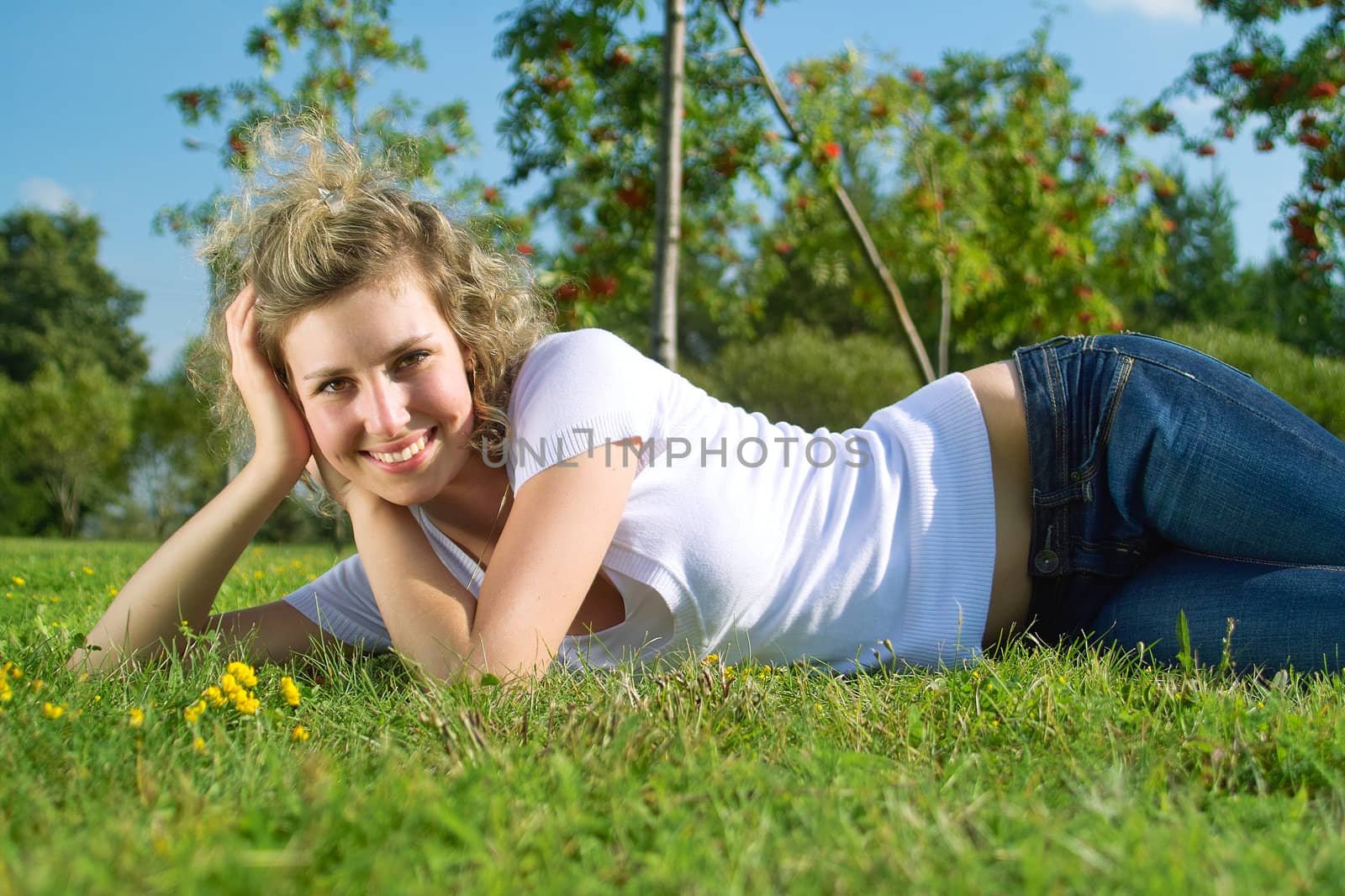 A beautiful lady lie on the grass in sunny day