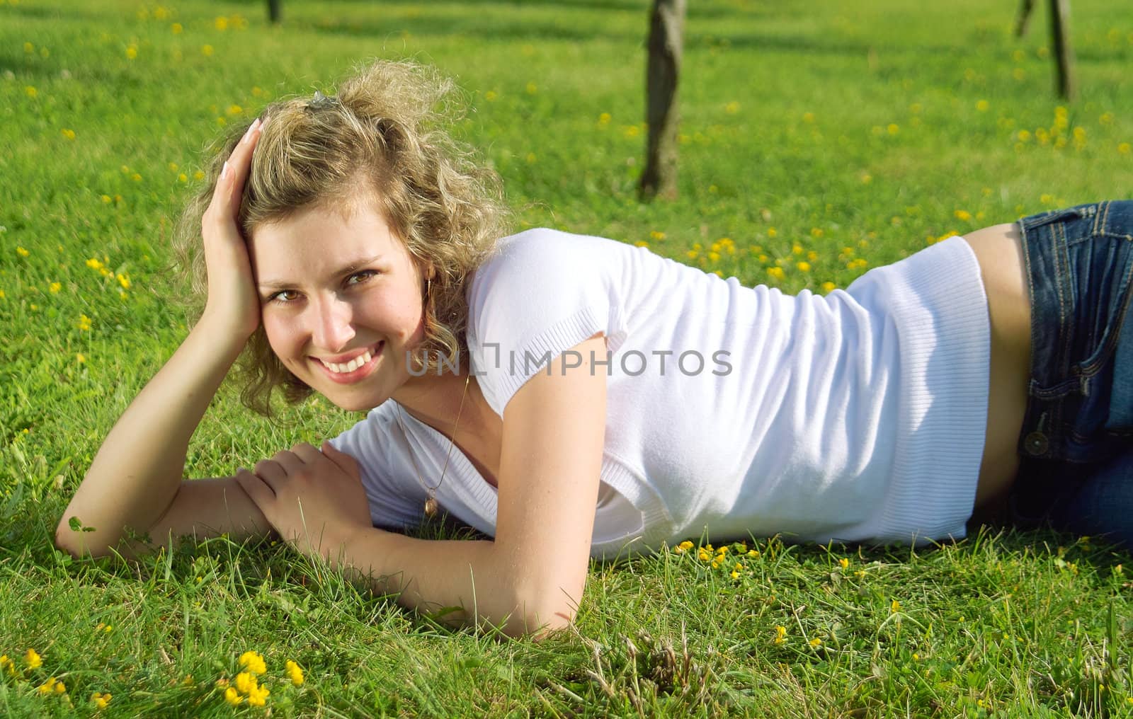 A beautiful lady lye on the grass in sunny day