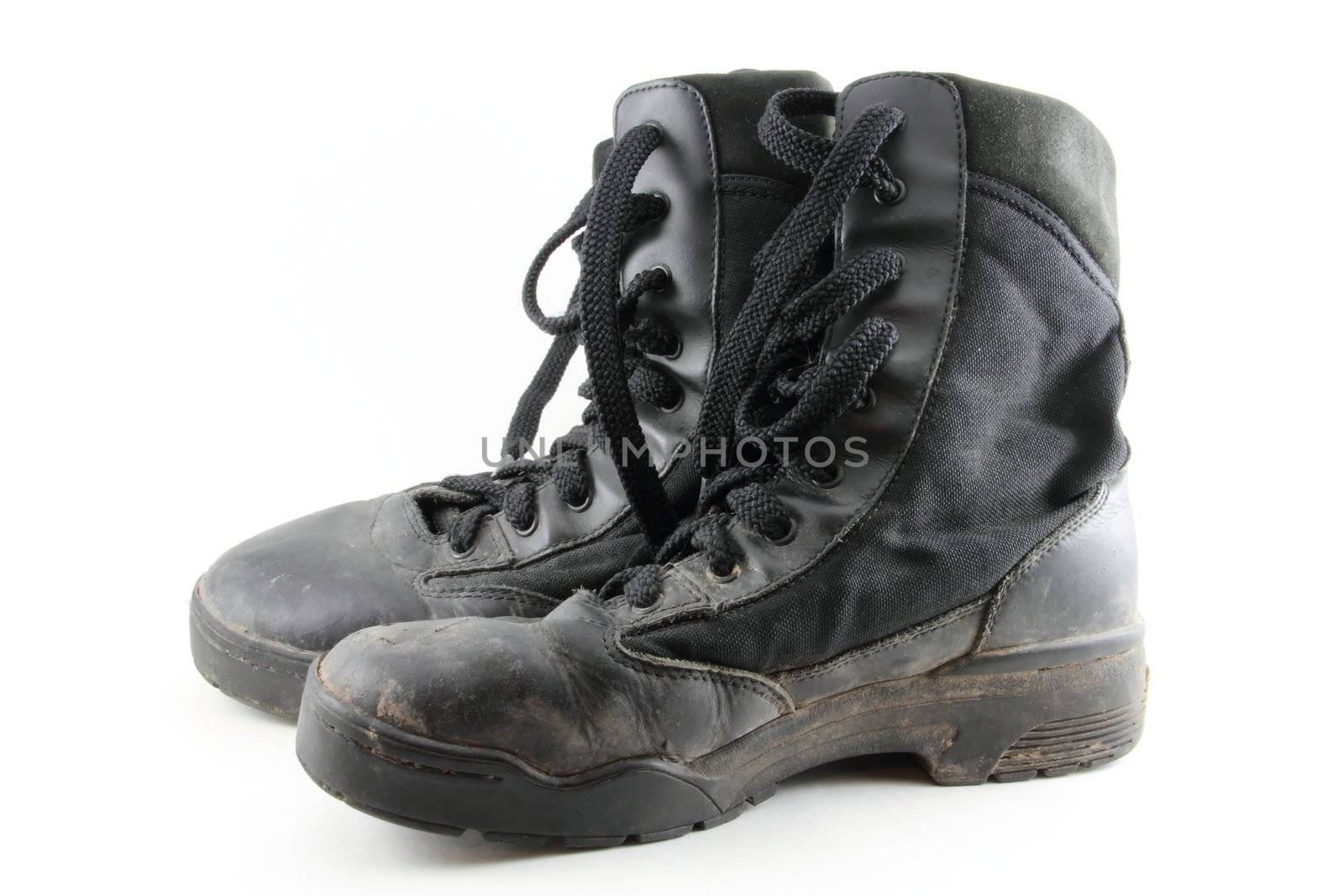 A pair of black, worn combat boots isolated on white.