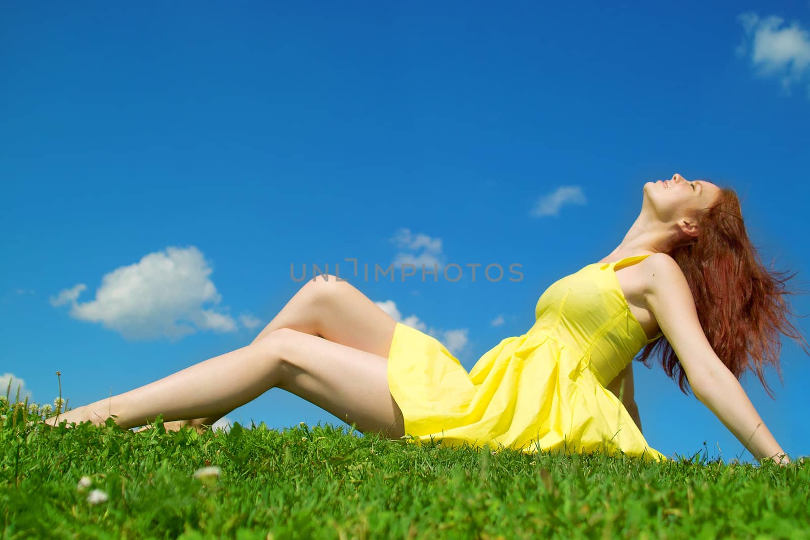 Beautiful lady in yellow dress relaxing in the park