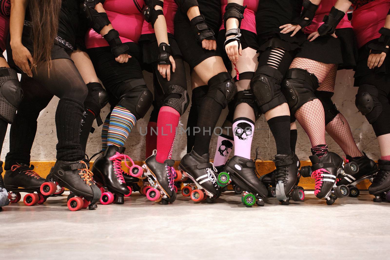 The roller skates and legs of a female Roller Derby team.
