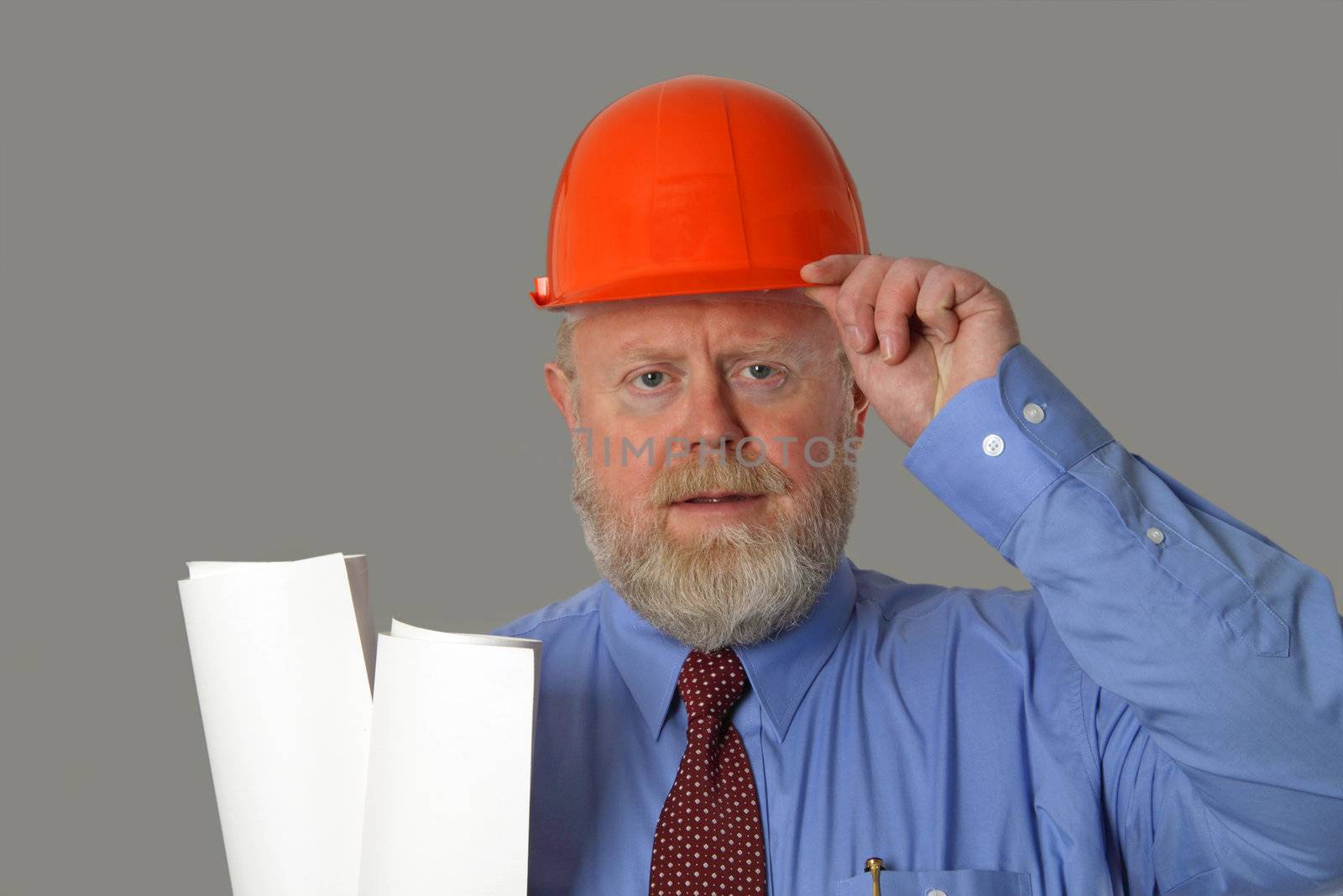 Architect with blueprints and hard hat on grey background

