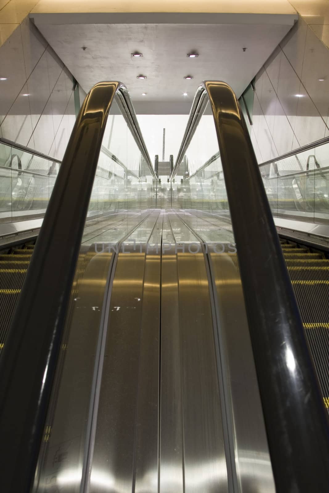escalator in a building. by cozyta