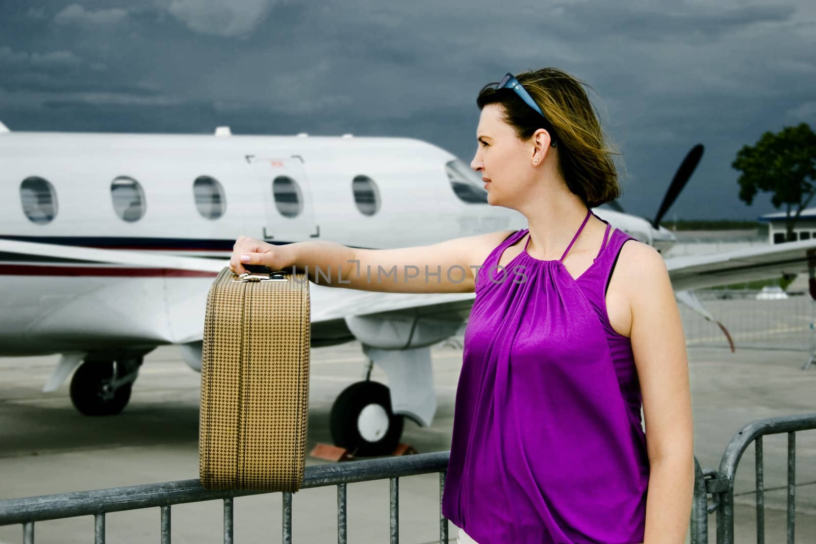 Young woman with valise around airpalne