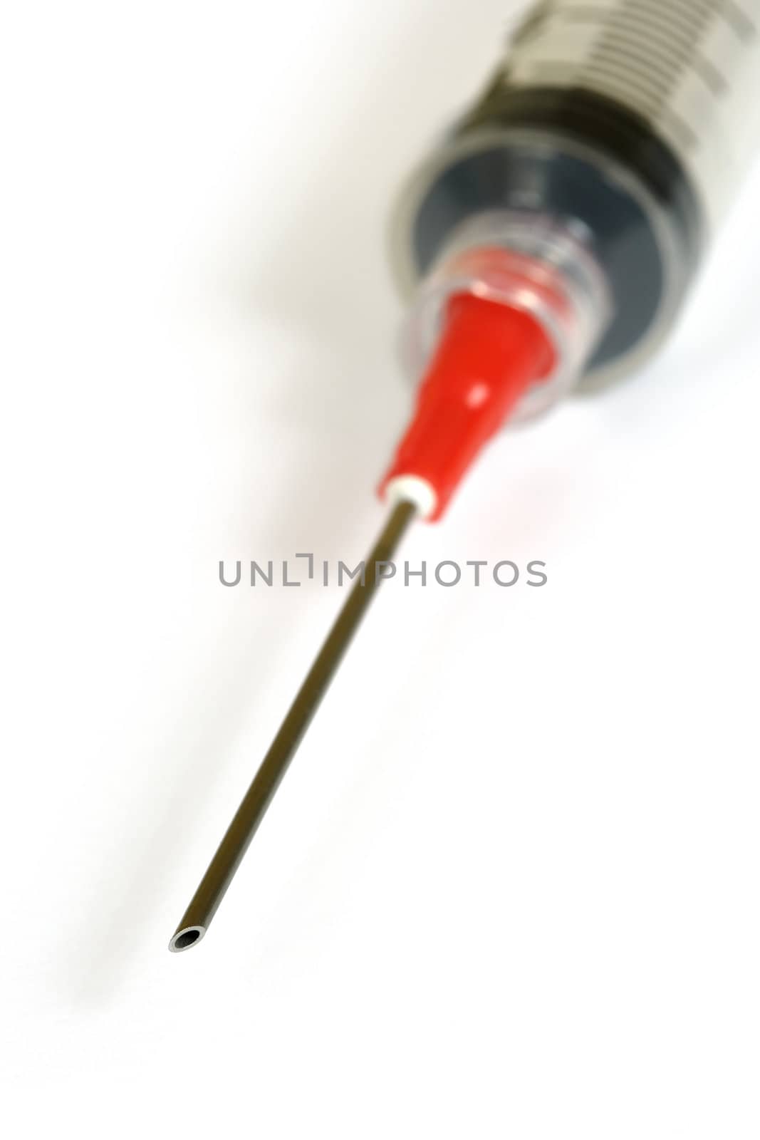 A macro image of the tip of a medical syringe.
