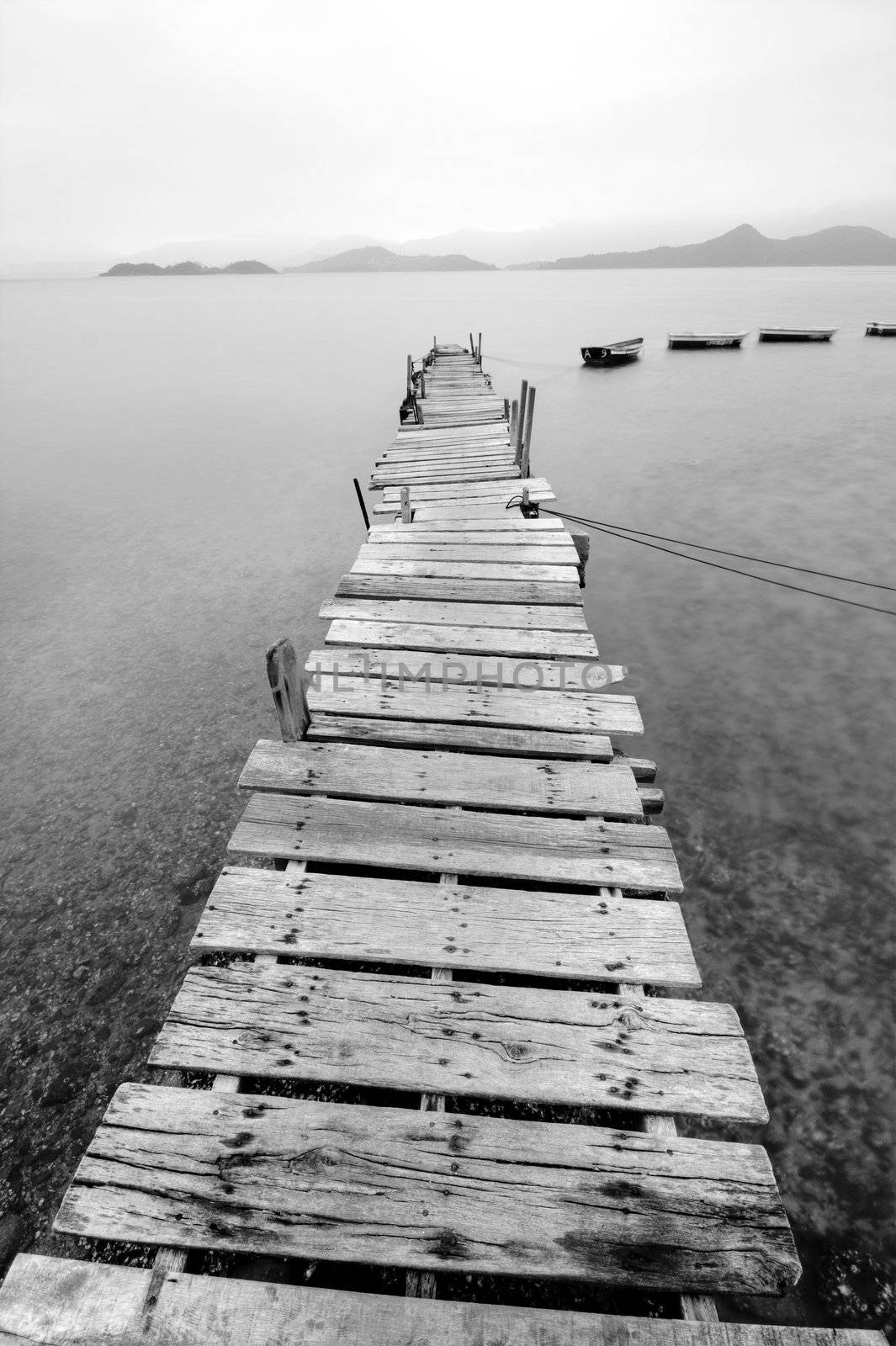 Looking over a desolate peer and a boat by cozyta