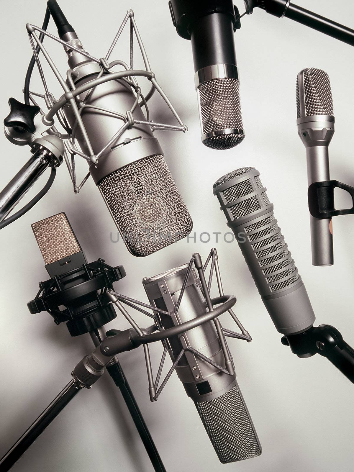 A series of recording studio microphones.  Slightly desaturated.
