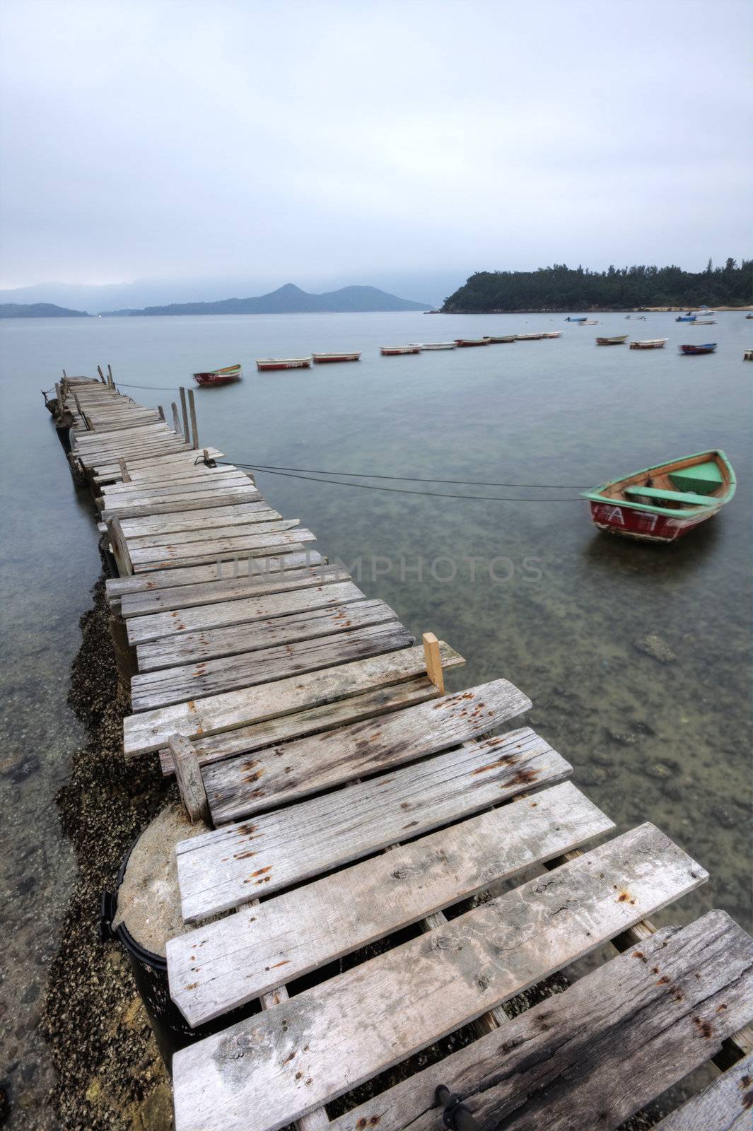 Looking over a desolate peer and a boat
