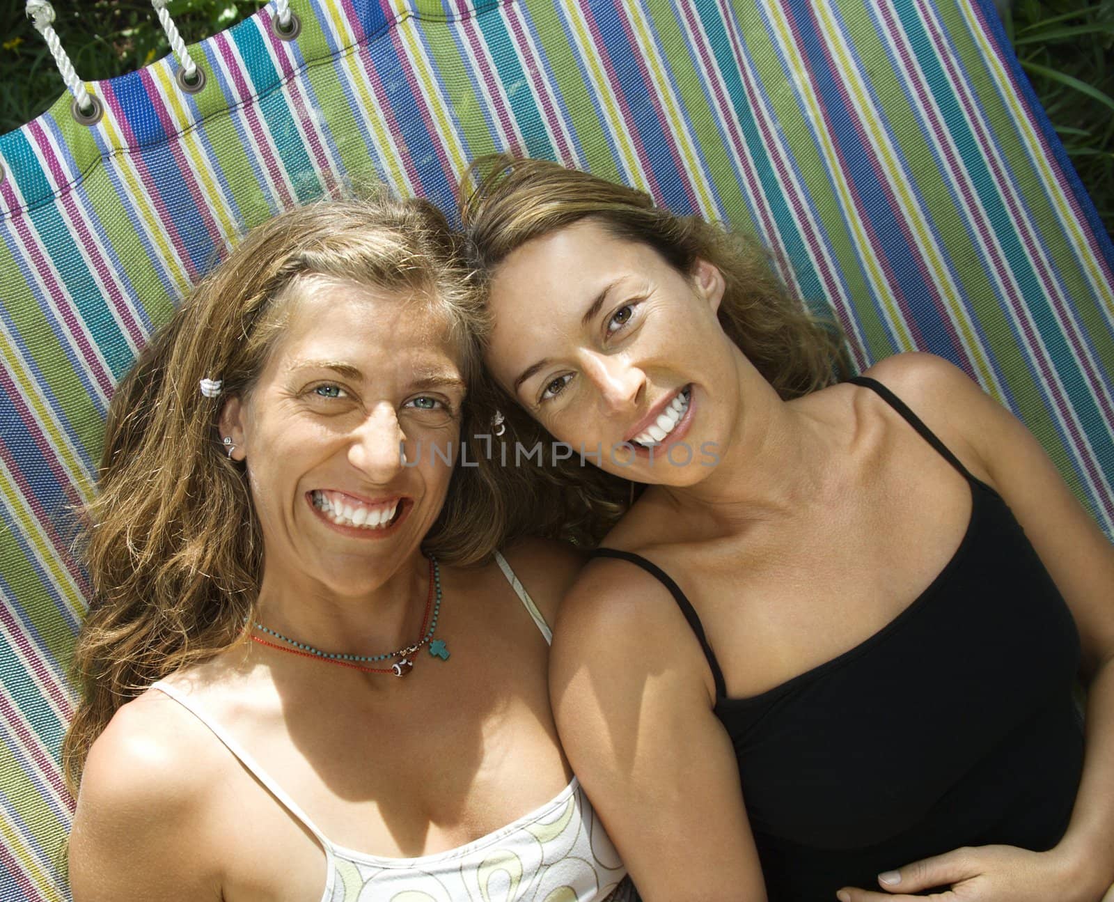 Caucasian mid-adult women lying in hammock and smiling.