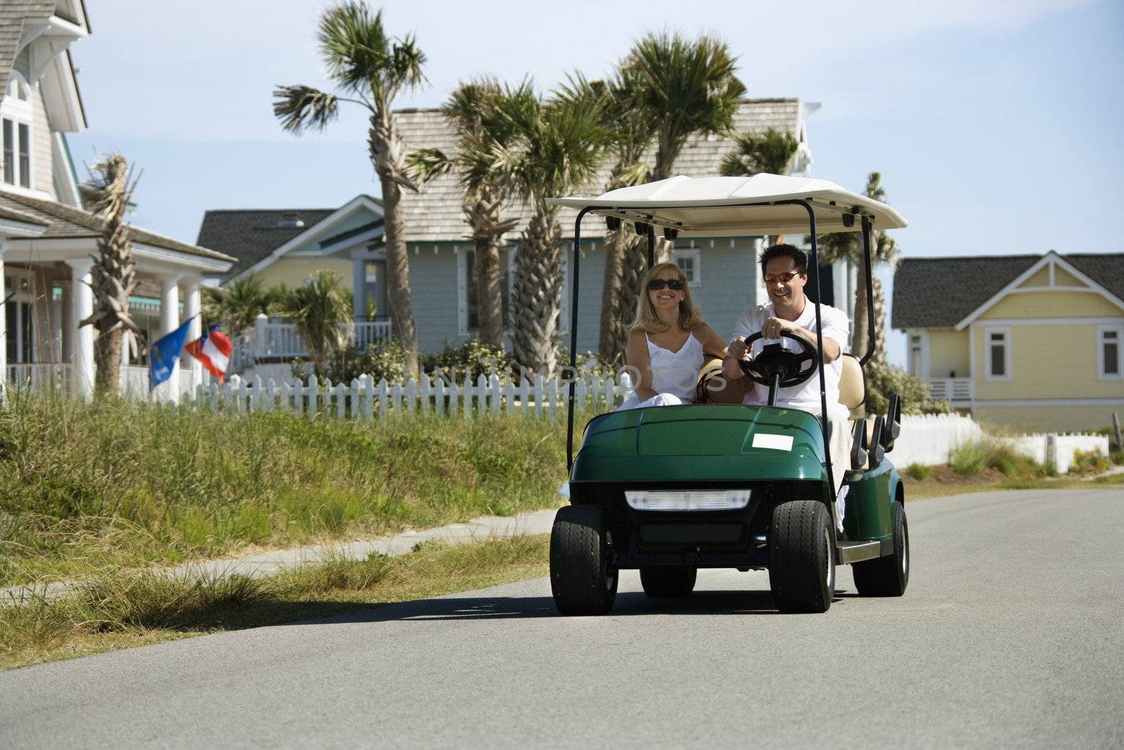 Couple in golf cart. by iofoto