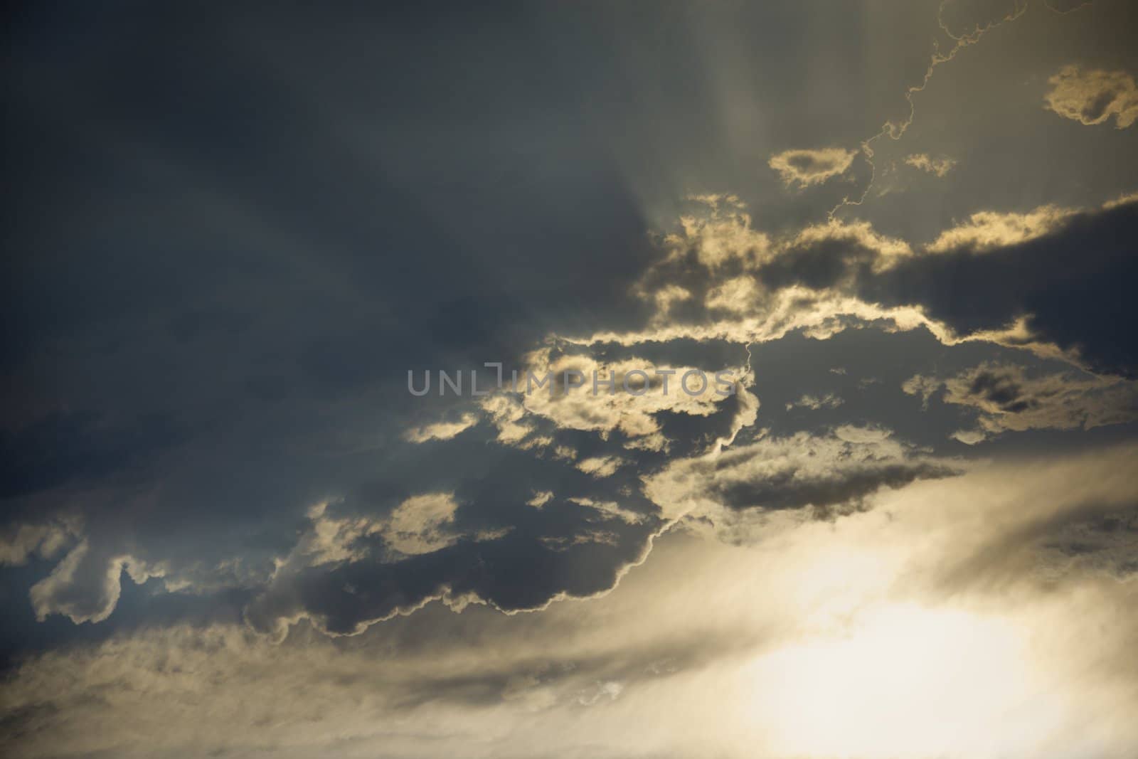 Sun shining through clouds. by iofoto