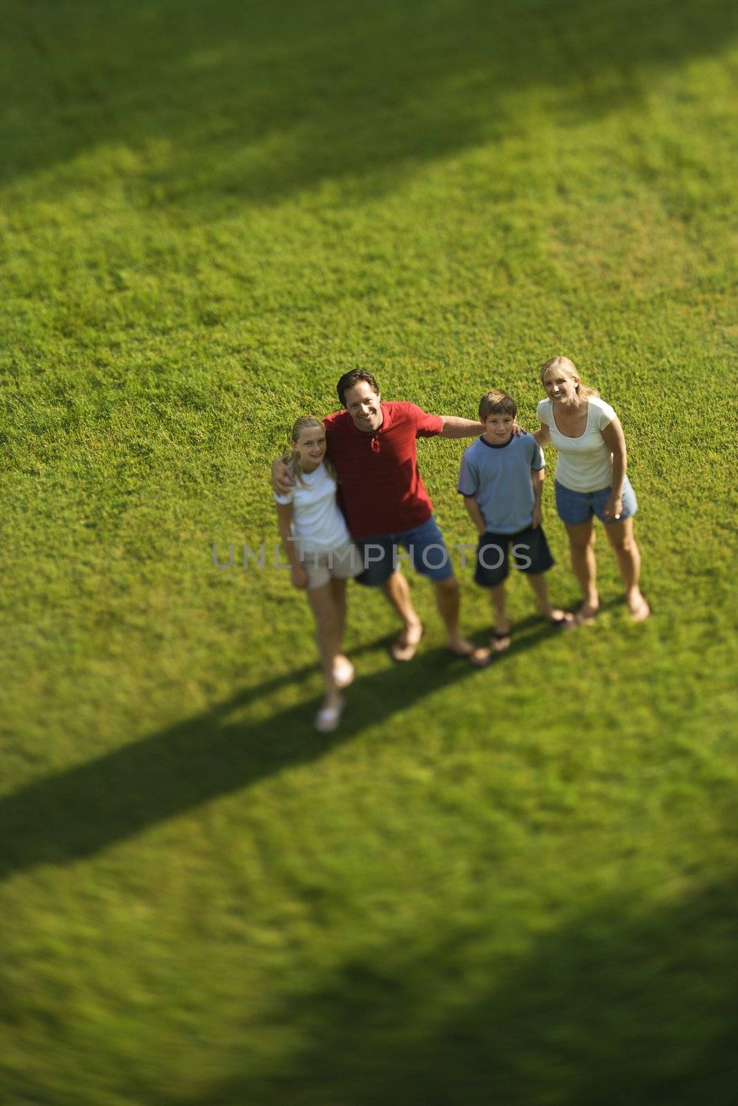 Family standing on lawn. by iofoto