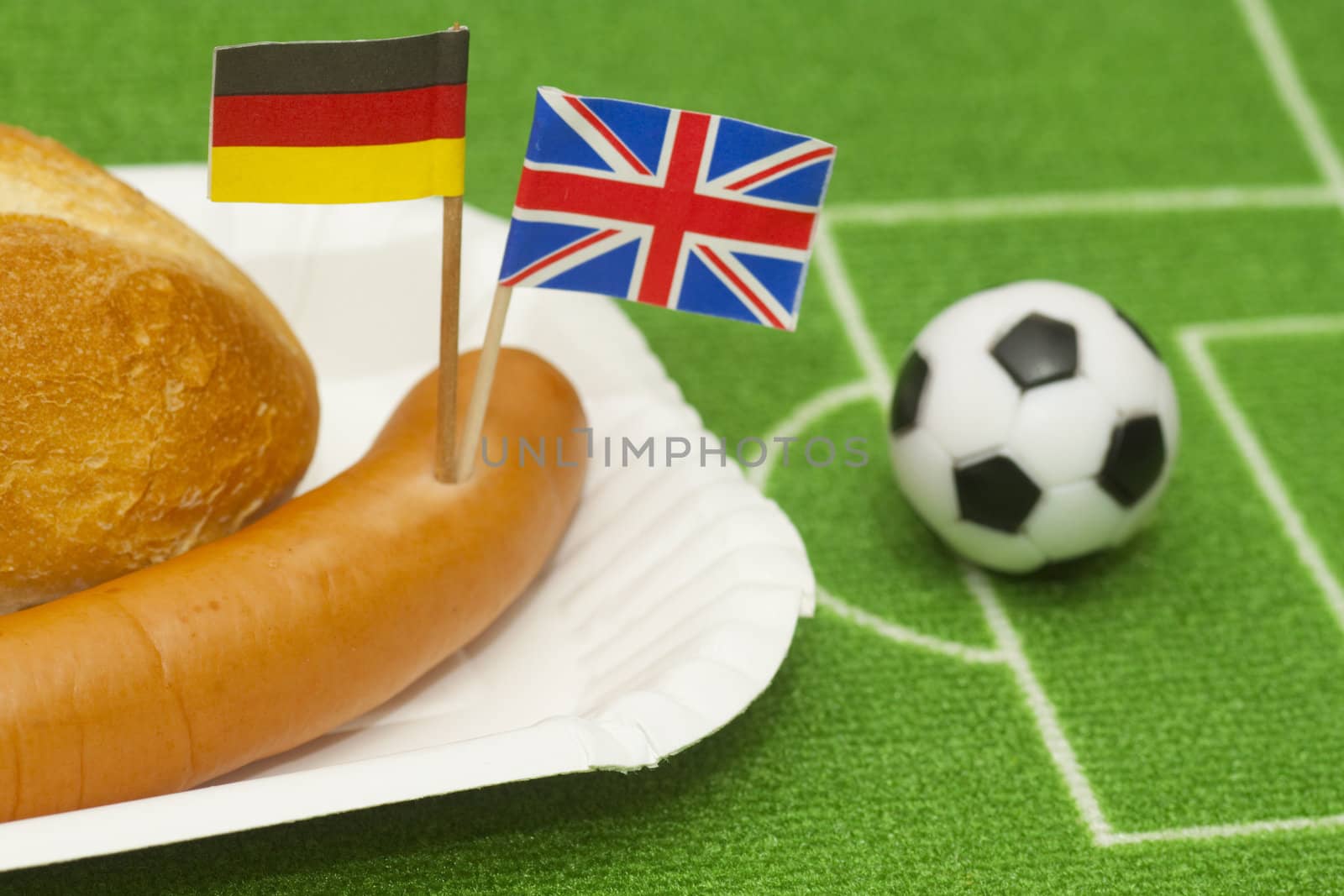 Sausage with roll on a football field background with soccer ball