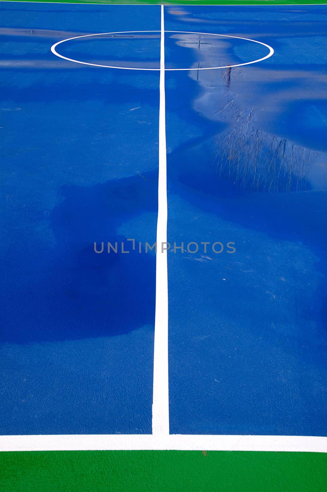 A blue and green basketball court after a good rain.