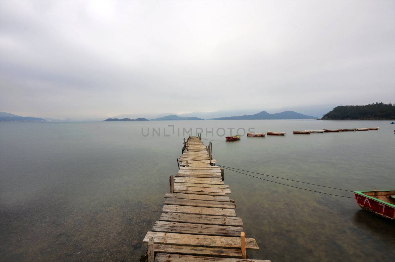 Looking over a desolate peer and a boat
