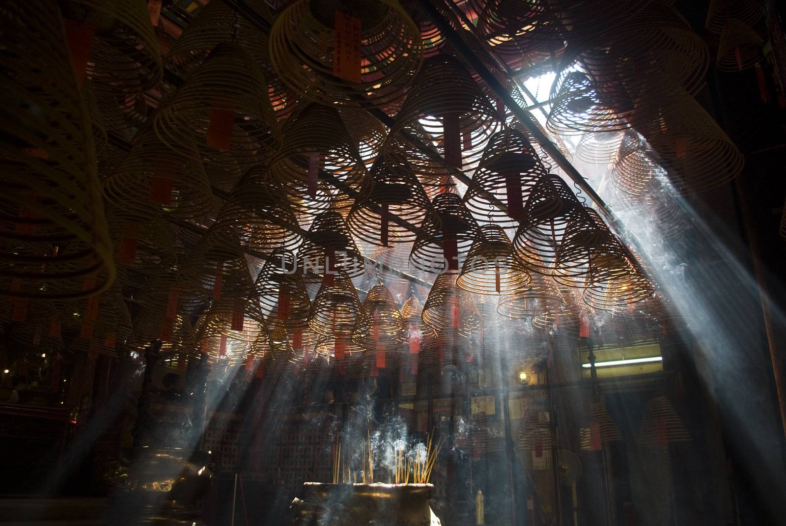 Incense and crepuscular rays in Hong Kong Man mo temple.
