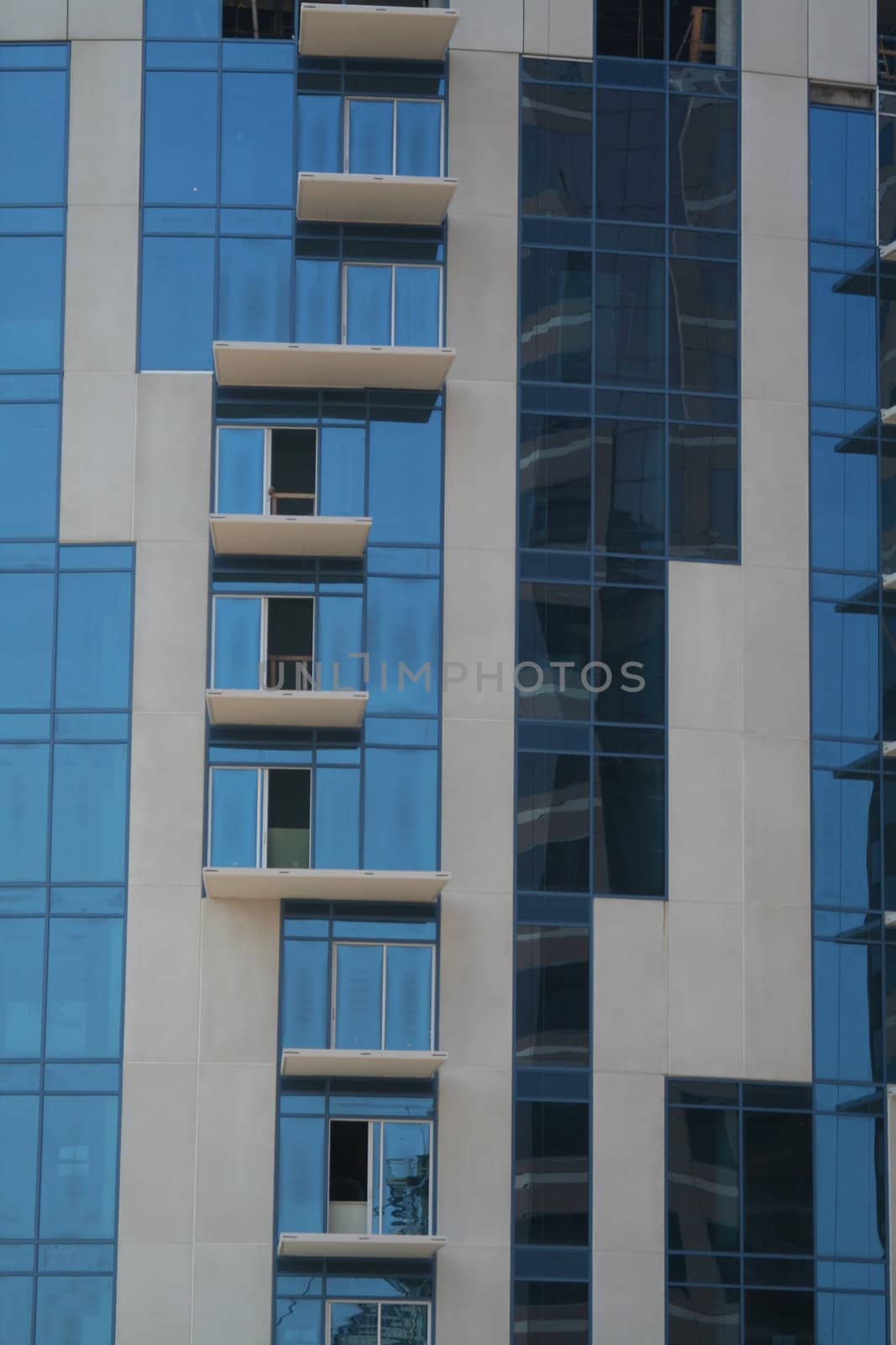 A detail of a new glass and concrete building under construction.