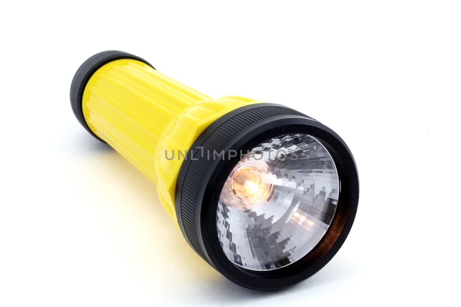 A flashlight isolated on white with the bulb turned on.
