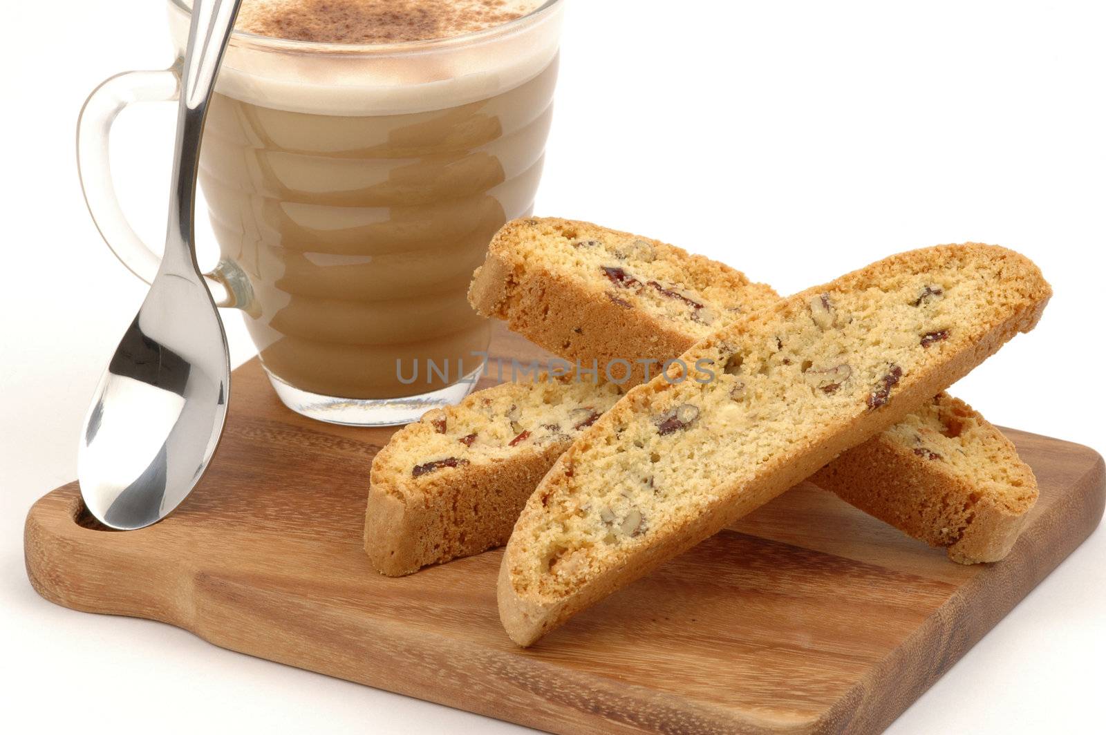 Tasty biscotti and cappuccino served on a wooden board.