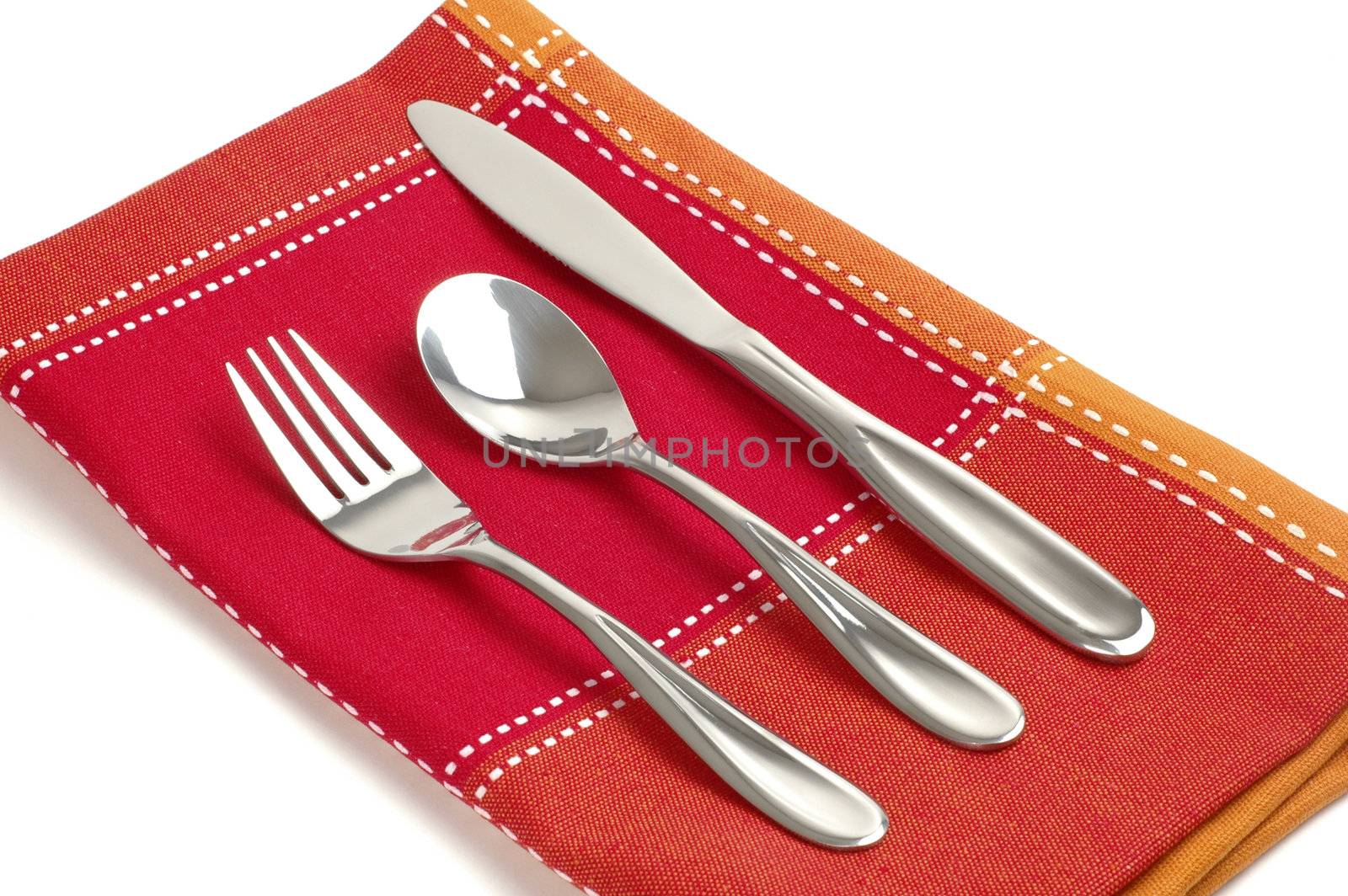 Silver eating utensils on a colorful  linen napkin.