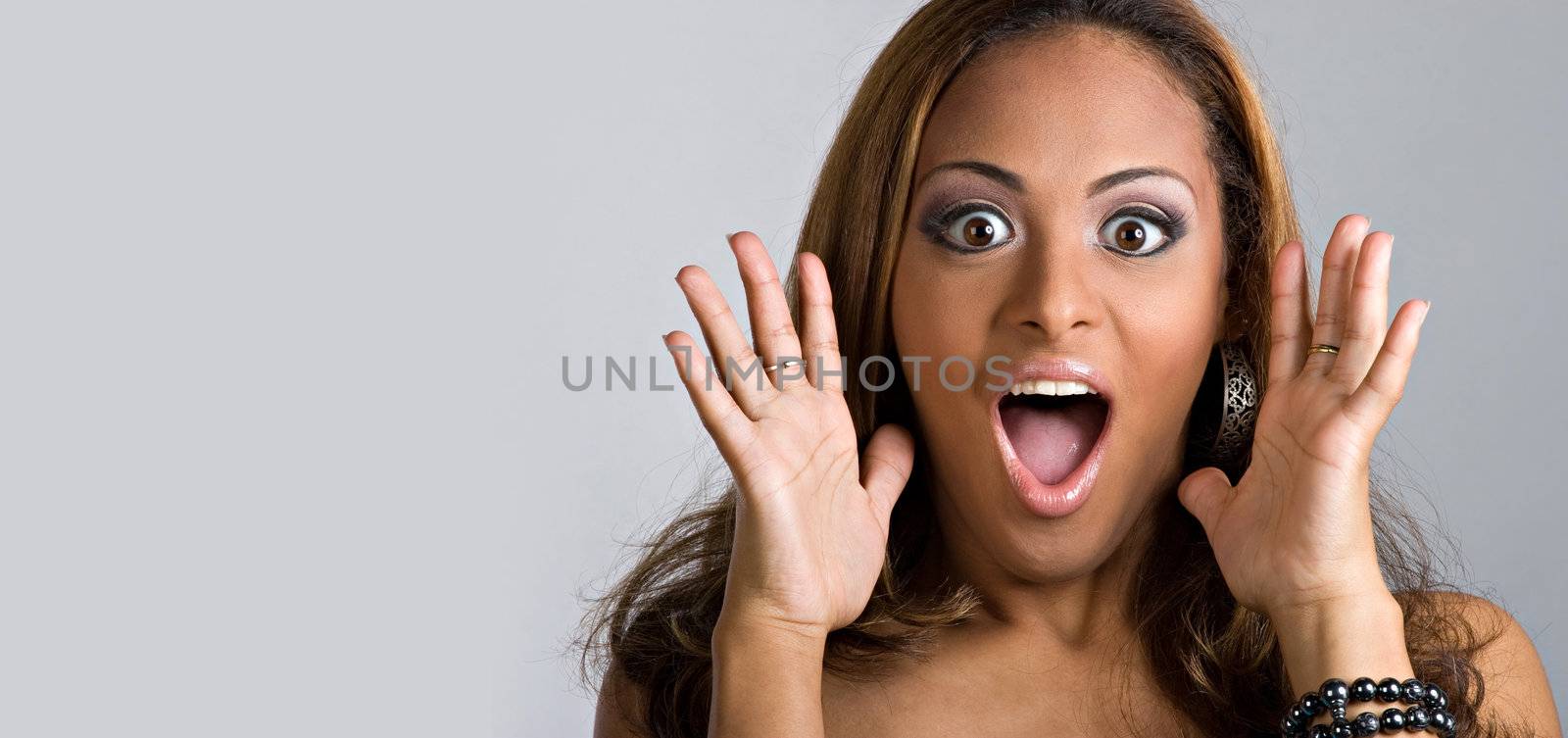 An amazed and shocked woman isolated over a silver background.  Lots of copy space for your text.