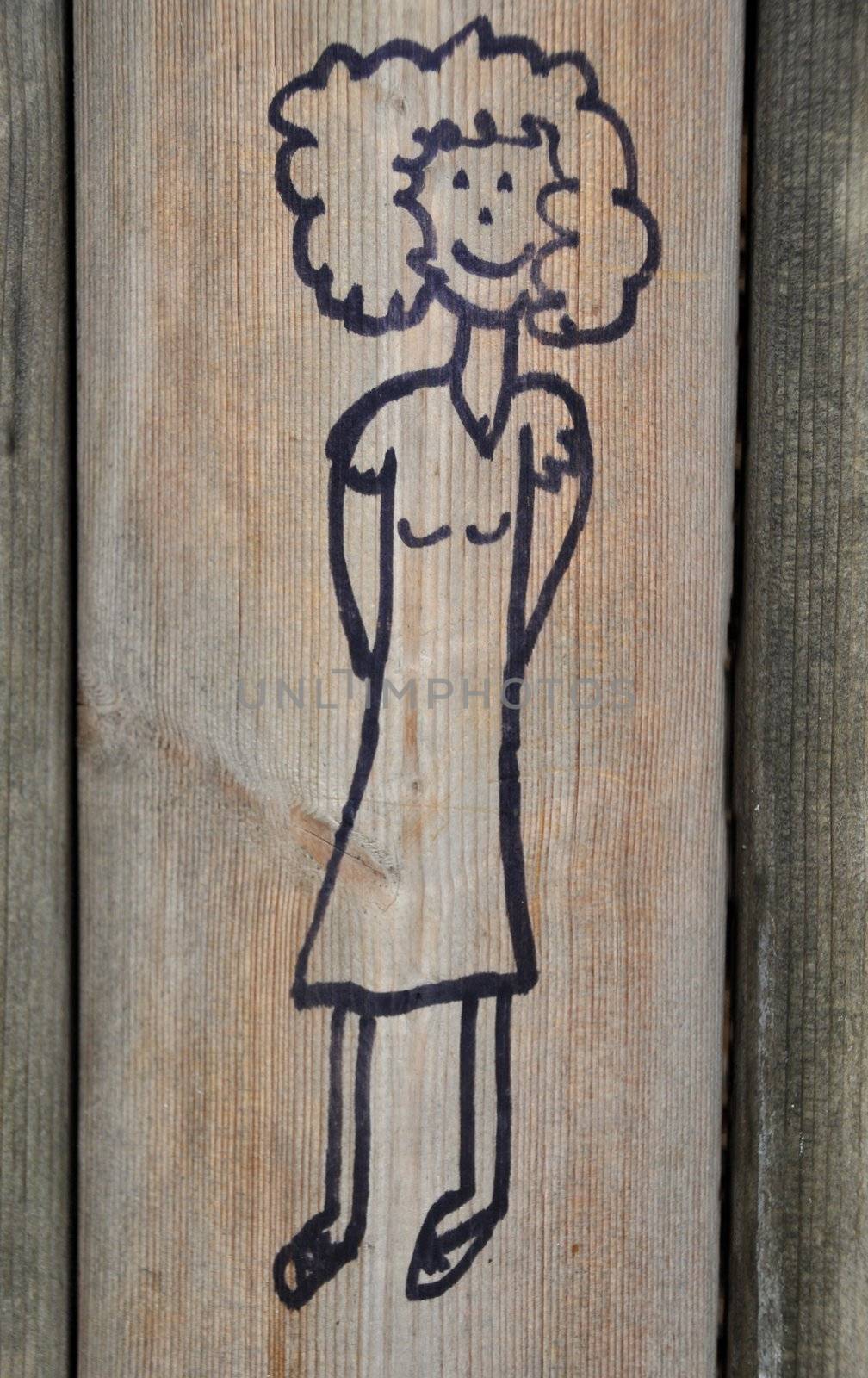 Cute marker scribble on wooden playground wall picturing a girl
