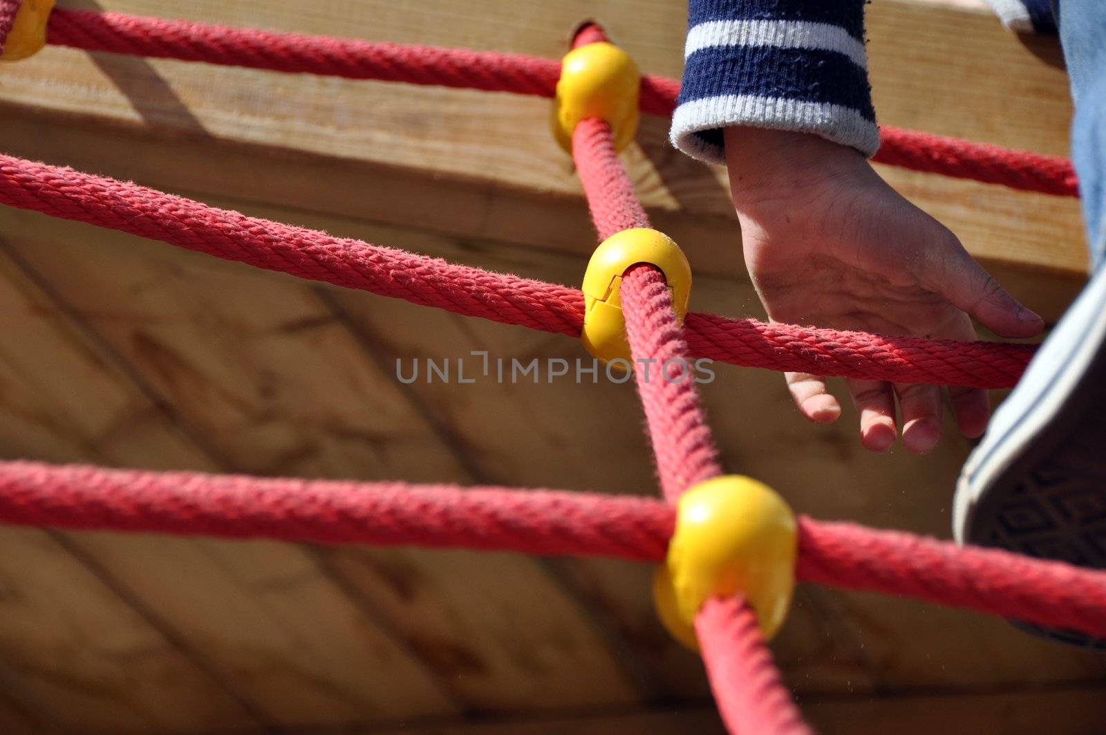 Climbing ropes construction on playground with boy (shoe/leg and arm visible)