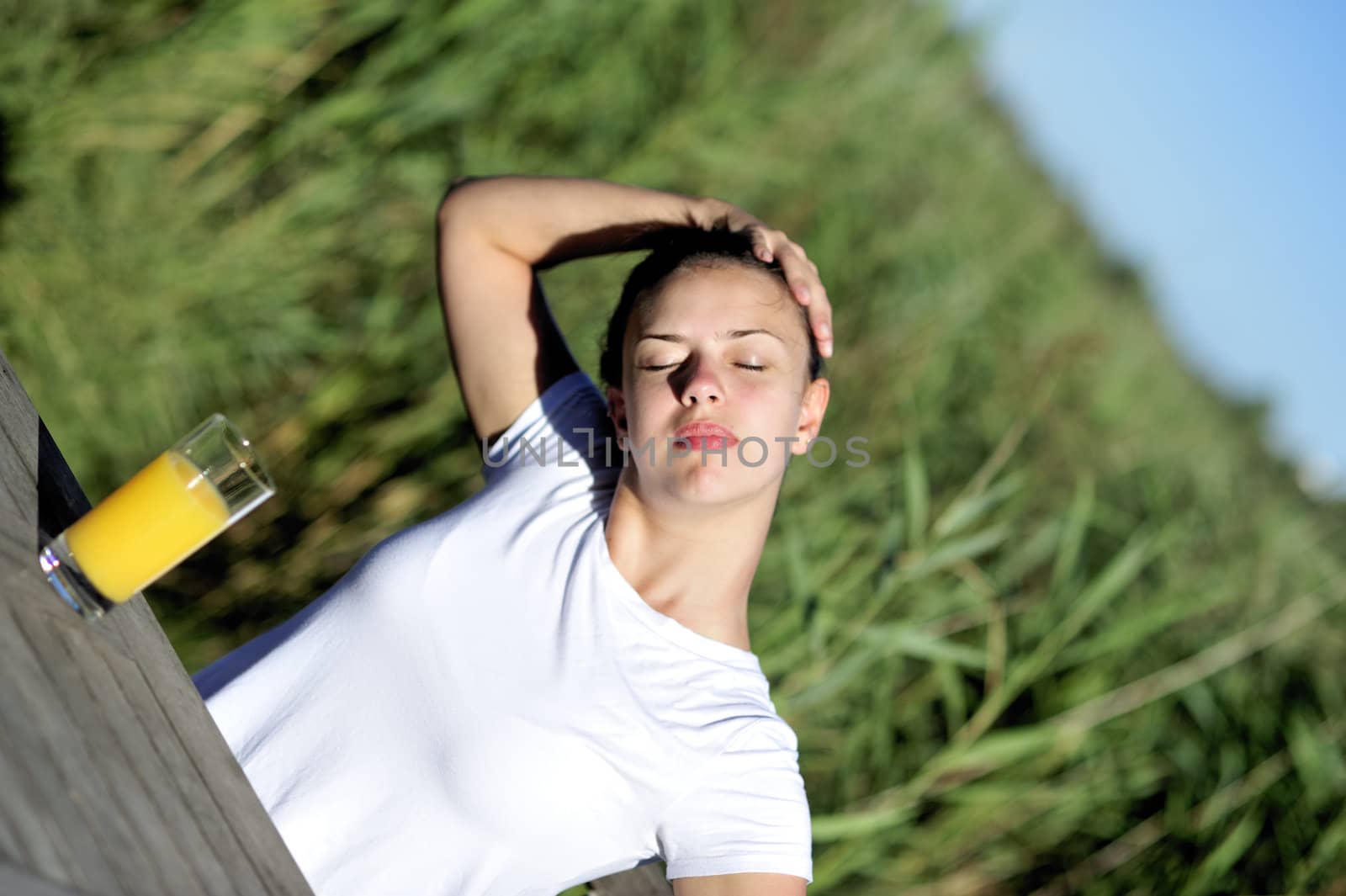 Woman doing stretching drinking her orange juice