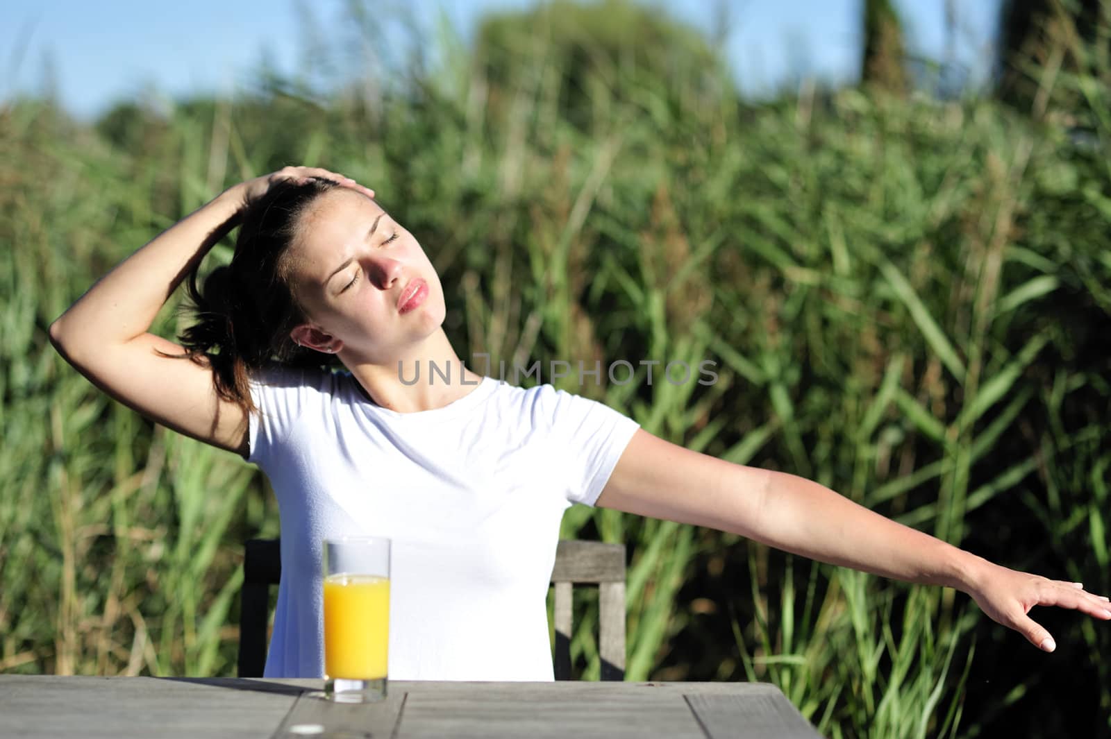 Woman doing stretching drinking her orange juice