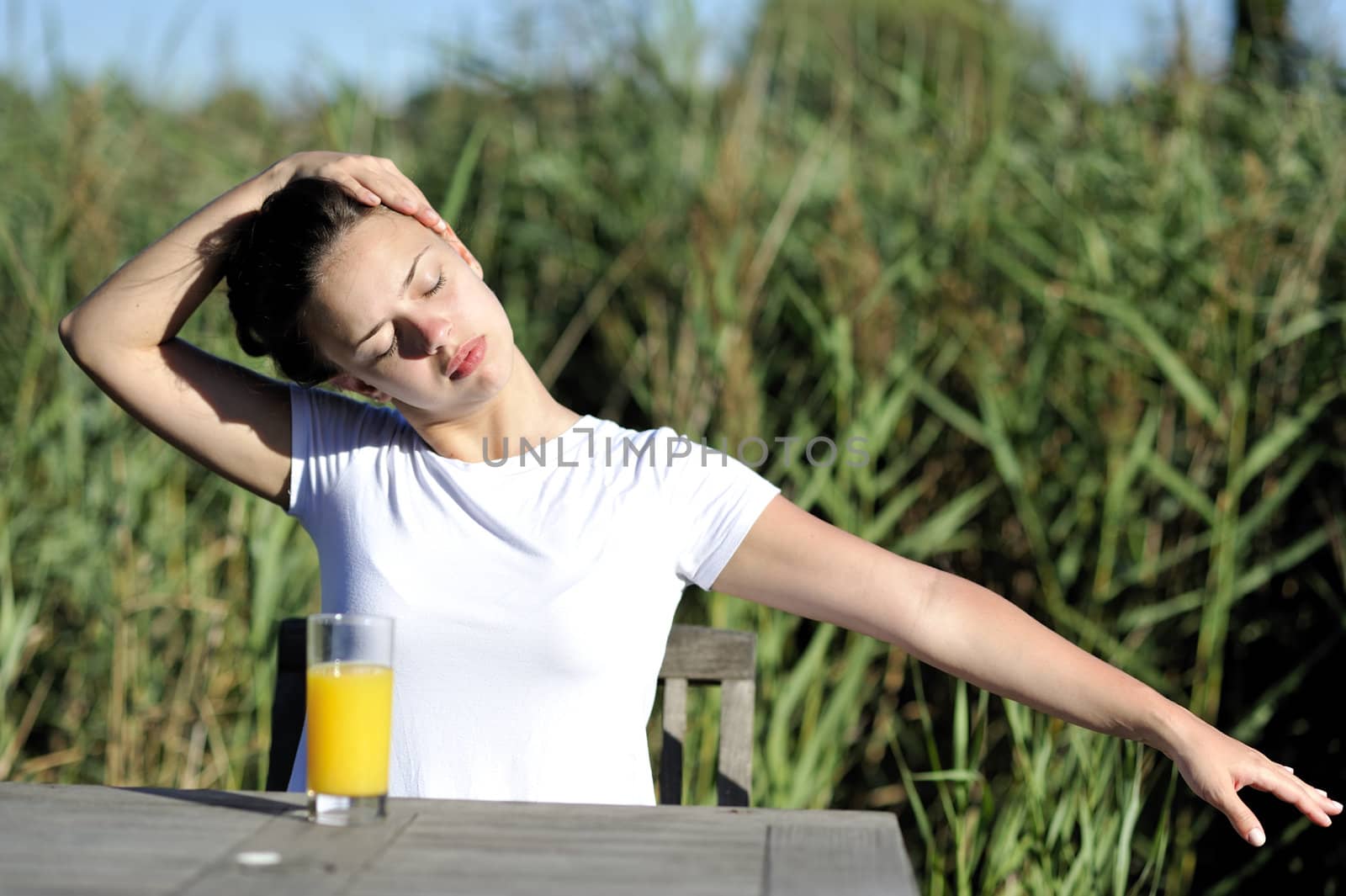 Woman doing stretching drinking her orange juice