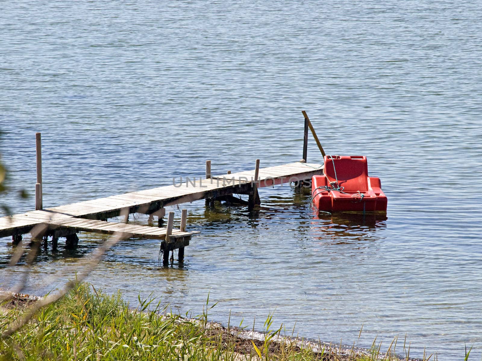 Small beautiful wooden pier jetty with a floating armchair