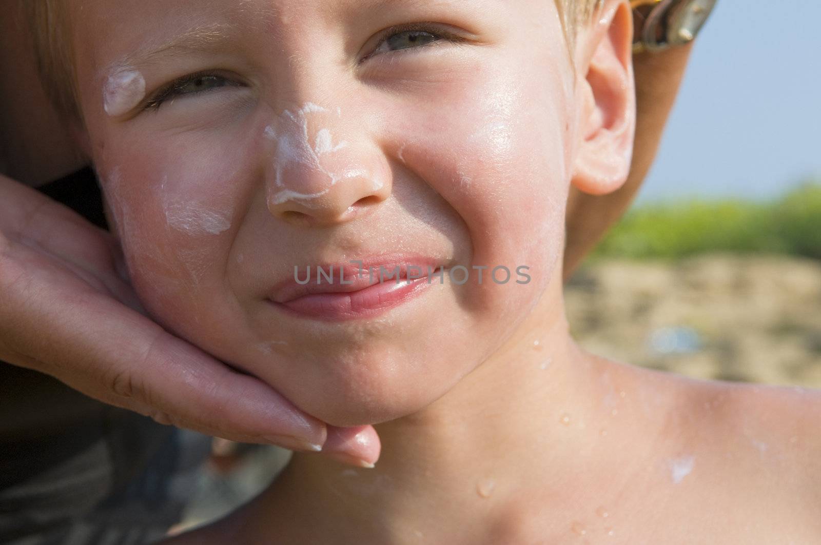 The boy smear with a cream from sunburn